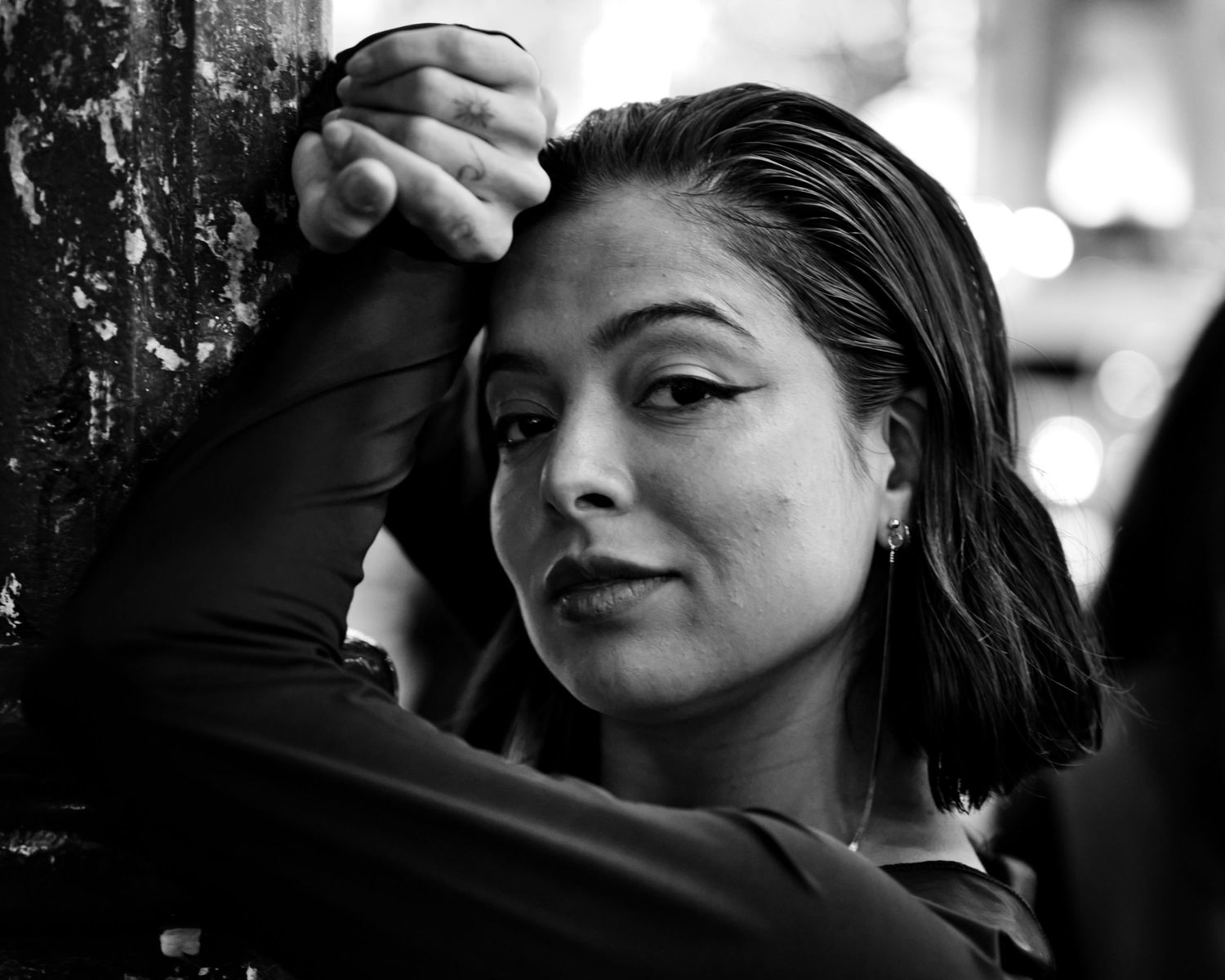 Dramatic black and white portrait with theatrical lighting and expressive pose.