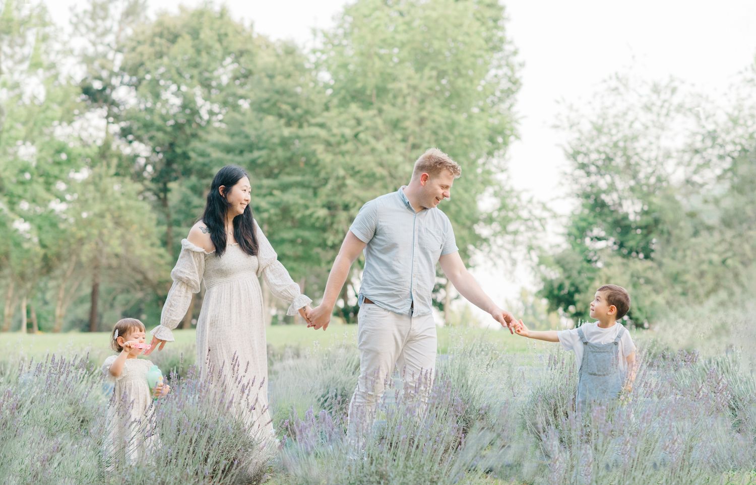 family walking through lavender field by Richmond newborn photographer