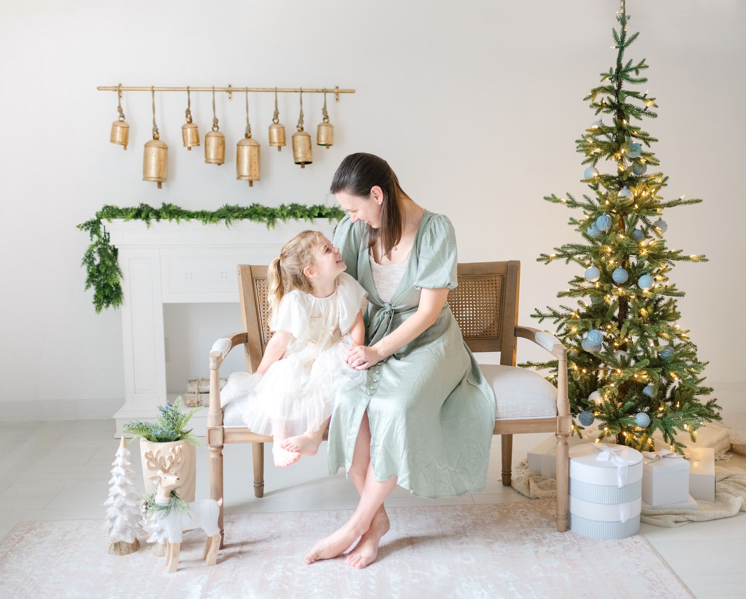 A series of holiday photos featuring a decorated Christmas tree, presents, and festive decor in a bright white studio setting.