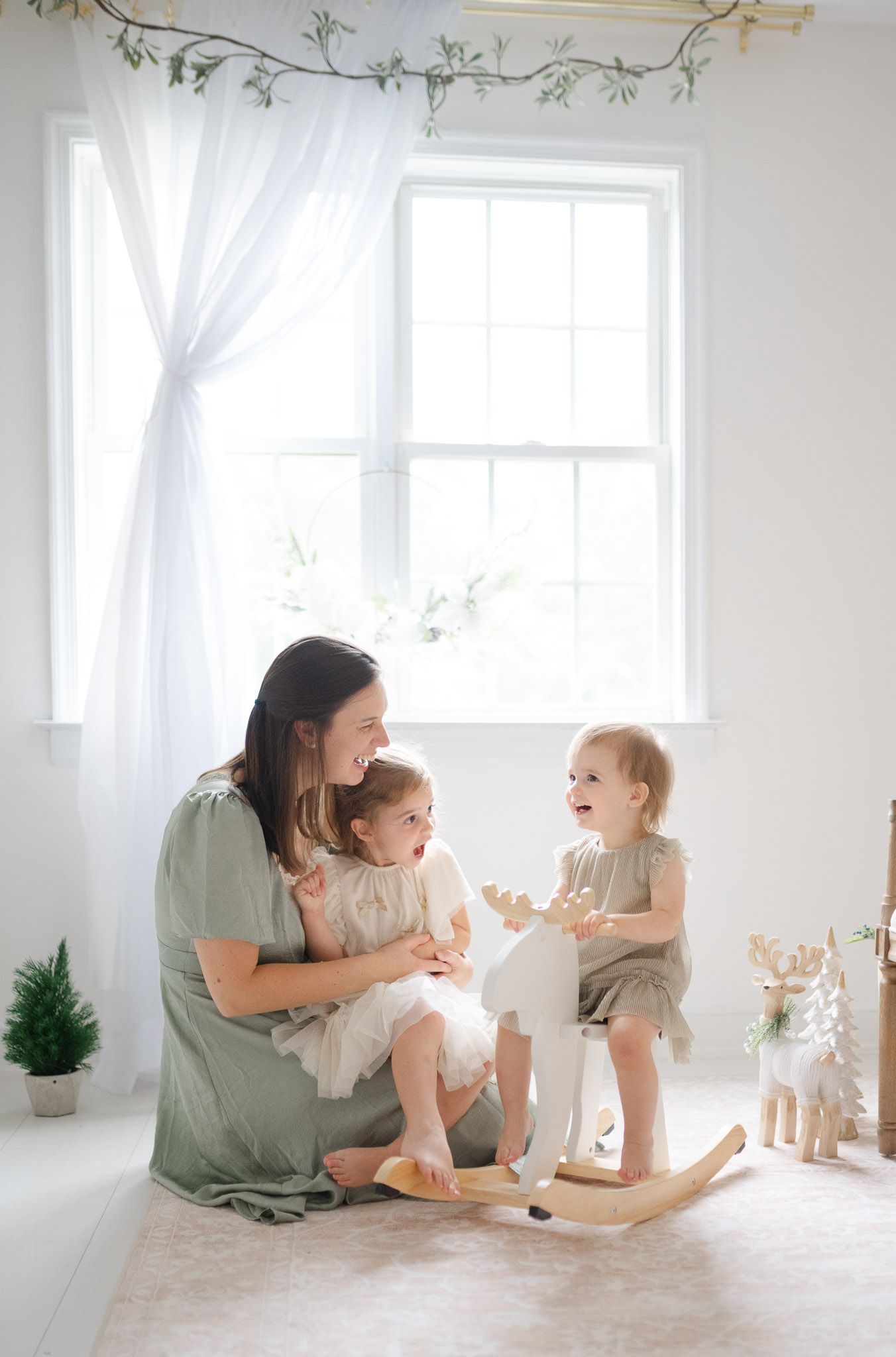 A series of four tender moments captured in a bright white studio space with delicate floral wall decor.
