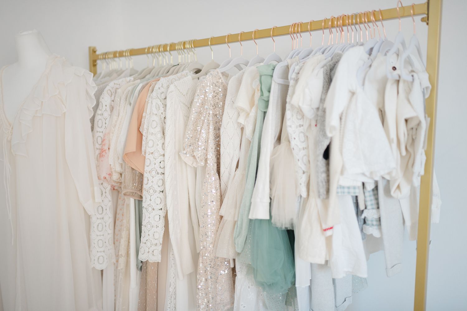 An assortment of delicate pastel clothes hanging neatly on hangers in Chesterfield Virginia photography studio