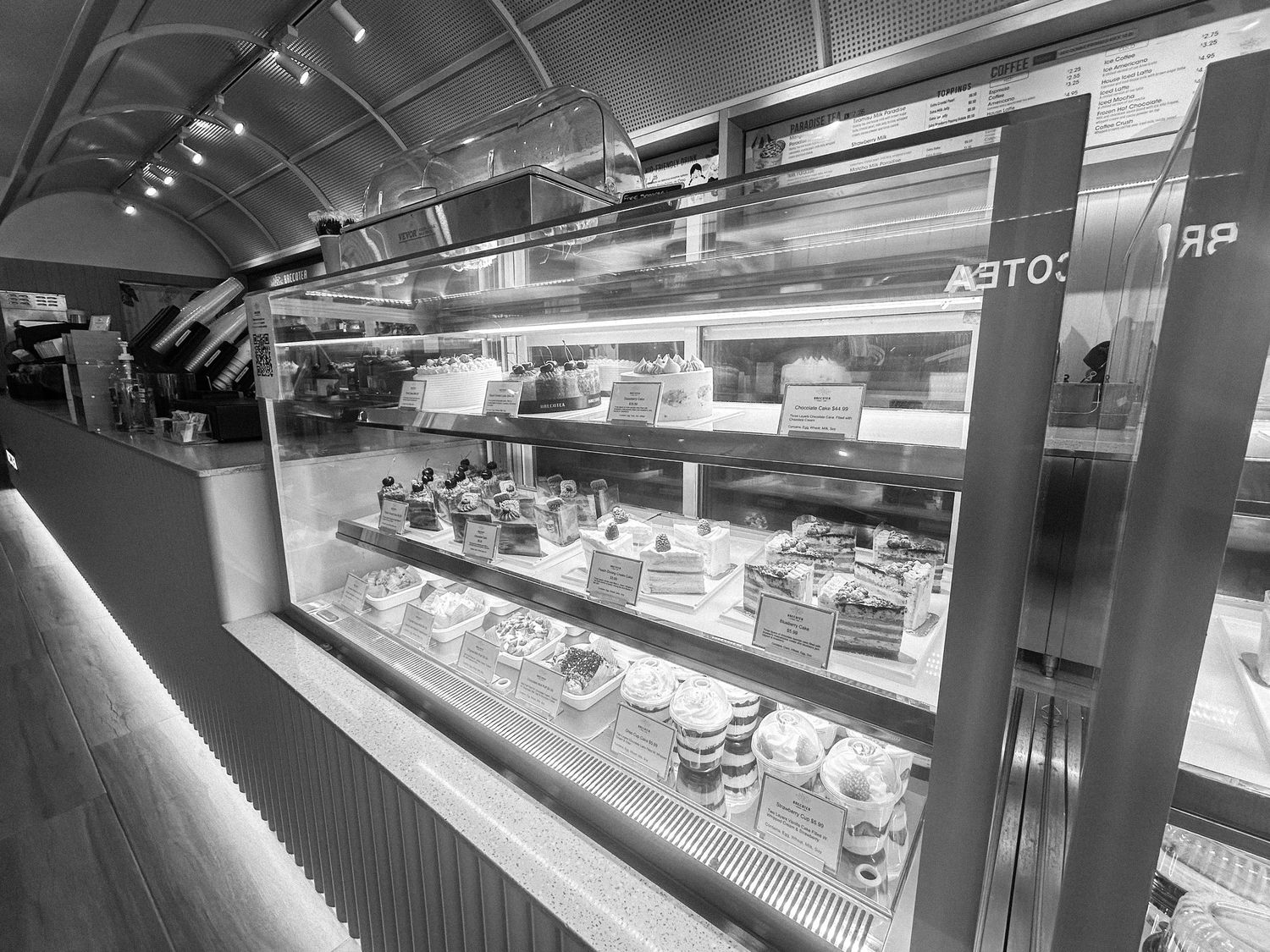 Black and white image of a sleek retail display counter with glass cases.