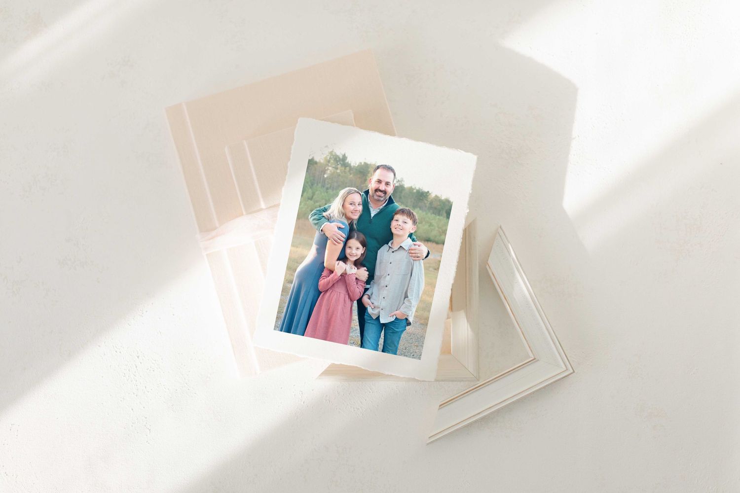 A collection of printed photographs scattered on a white surface with soft natural lighting.