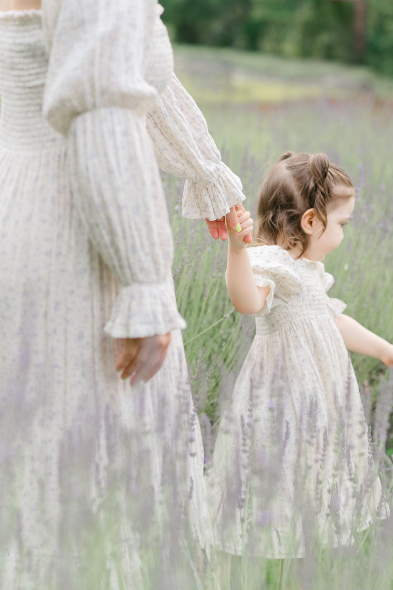 A series of dreamy images showing white lace dresses among purple lavender flowers in a summer field.