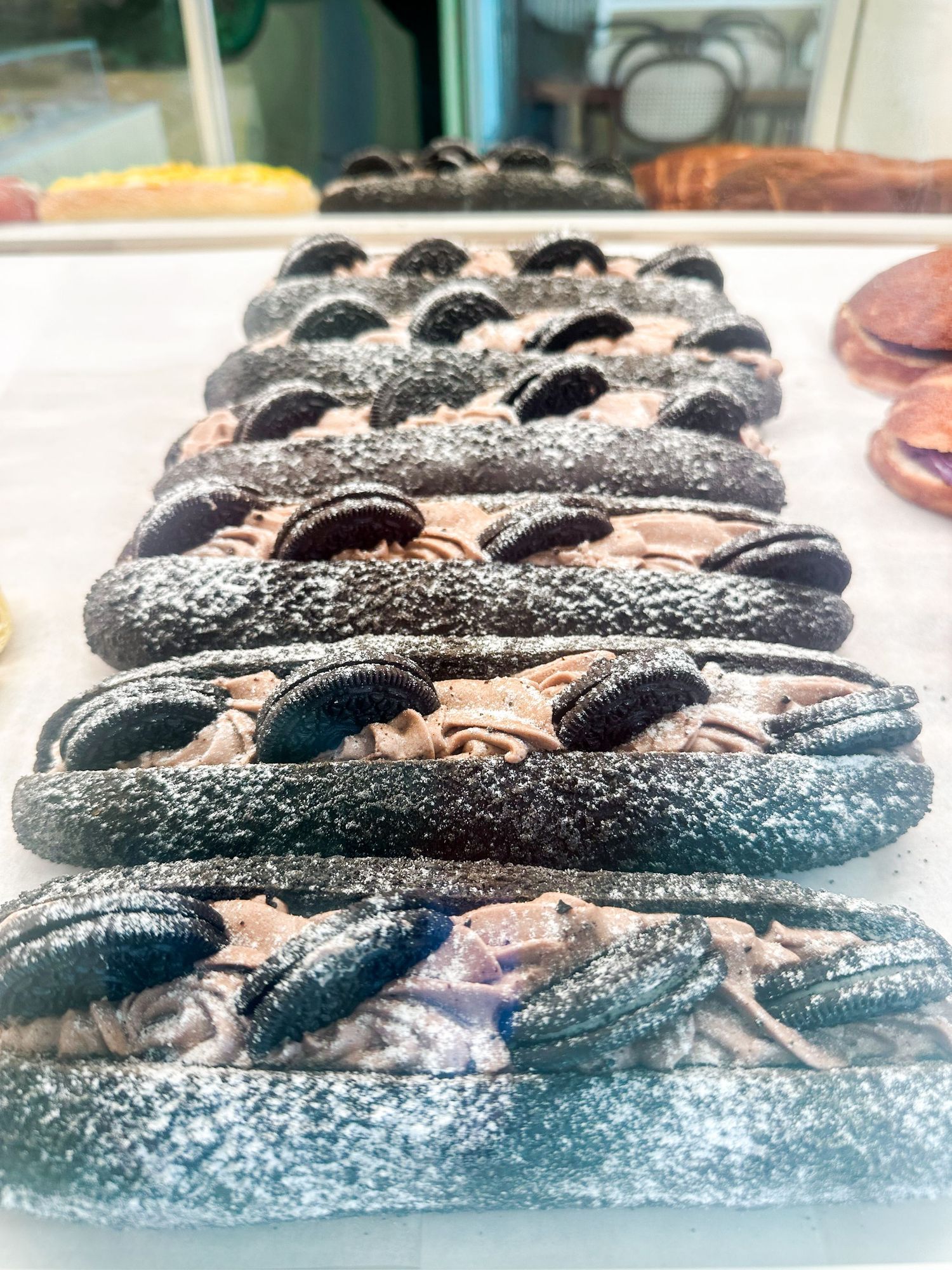 Artisanal chocolate pastries with powdered sugar coating on display.