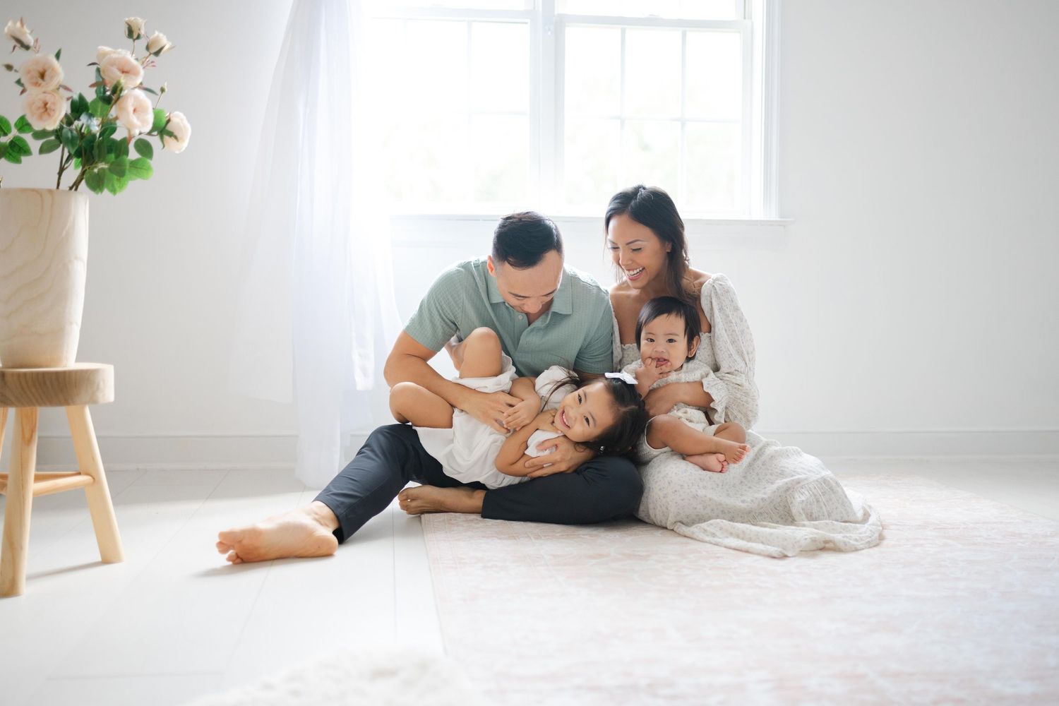 playful family portrait in front of bright light in Richmond newborn photography studio