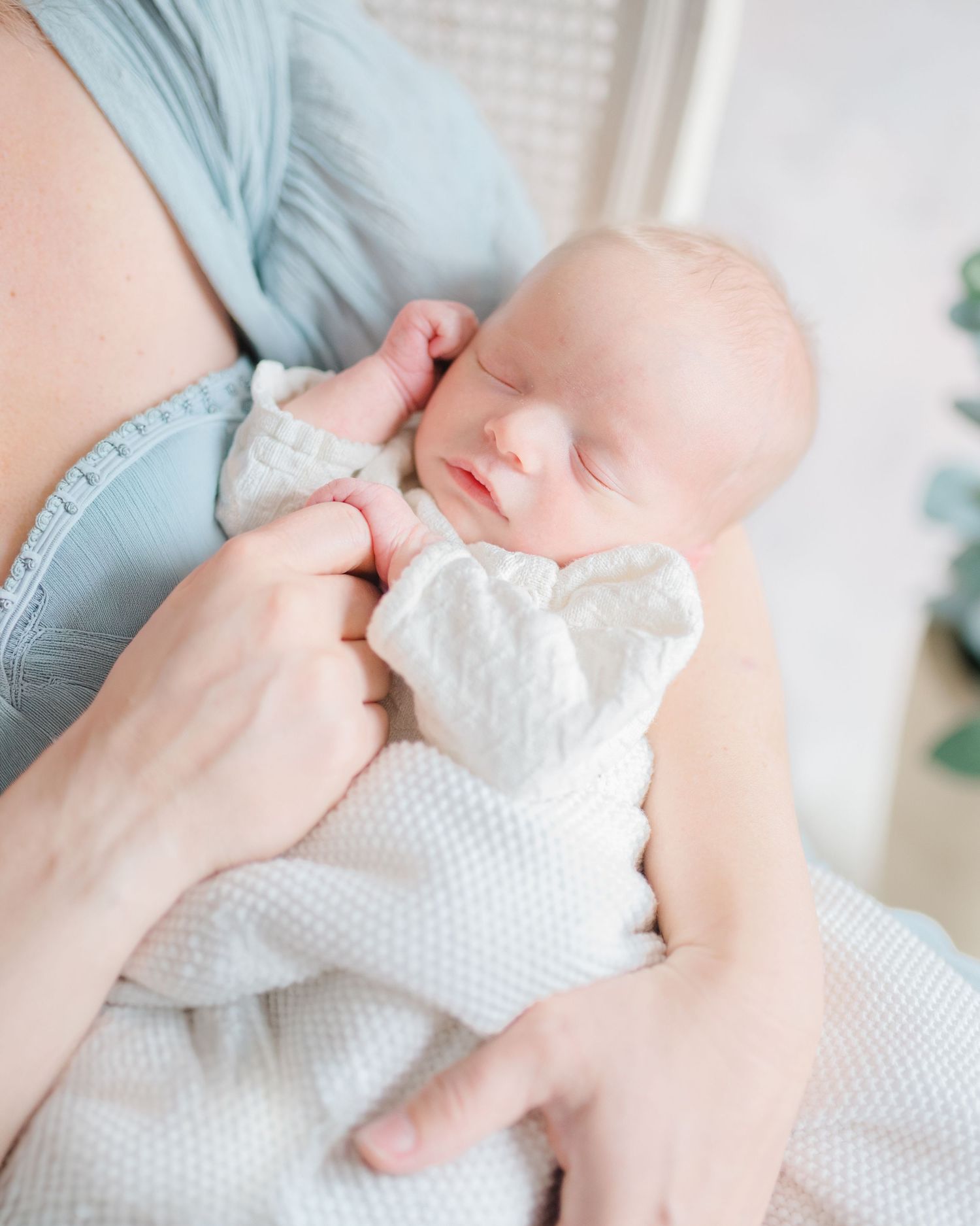 Mother holding newborn baby in soft natural light during a newborn photography session in Richmond, Virginia