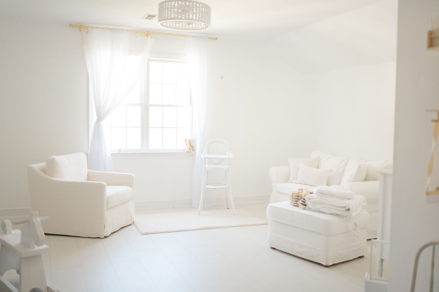 A bright and airy photography studio features white bedding, minimalist decor, and natural light streaming through windows in Midlothian Va