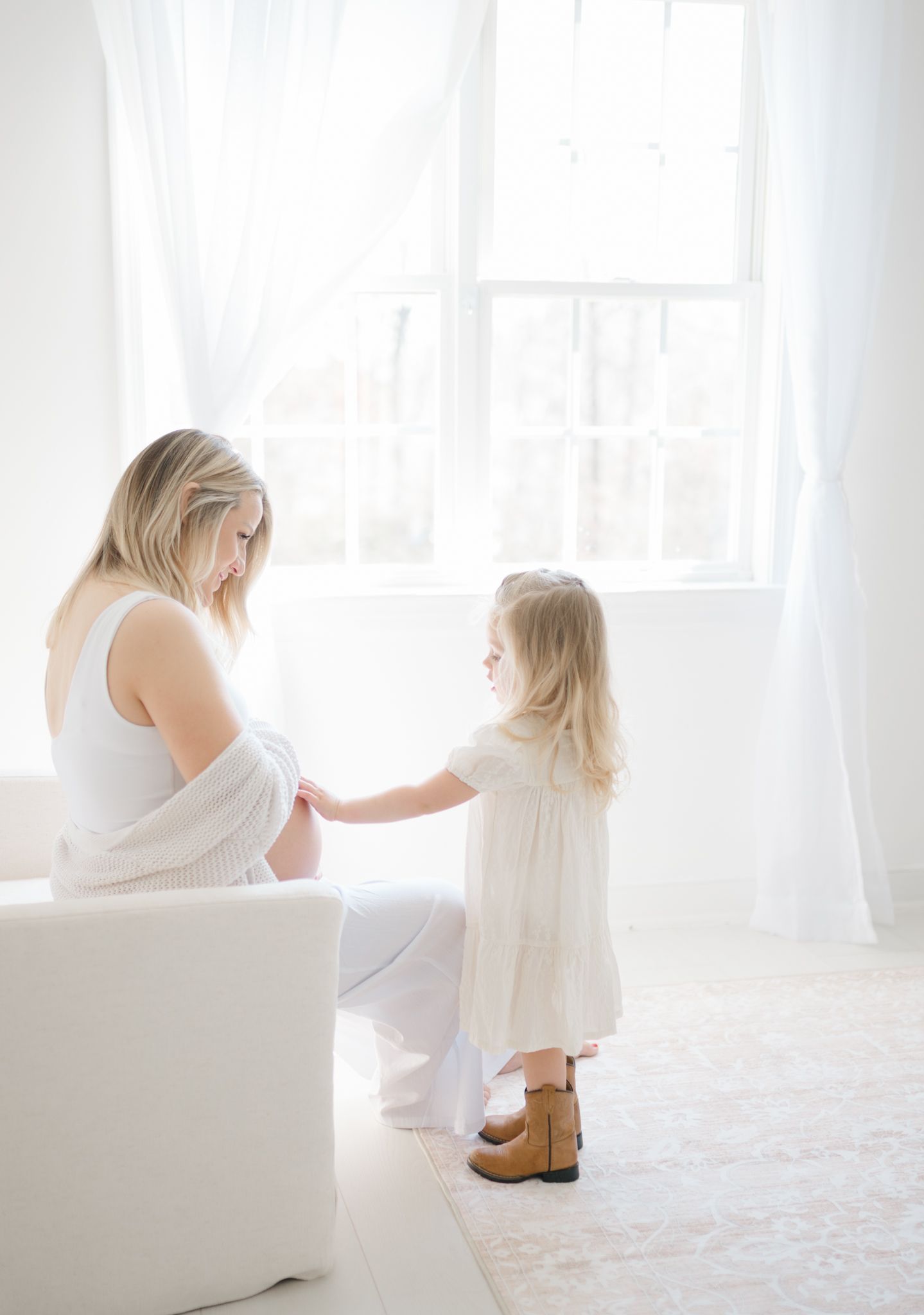 toddler holding mom's stomach in maternity session by Richmond newborn photographer