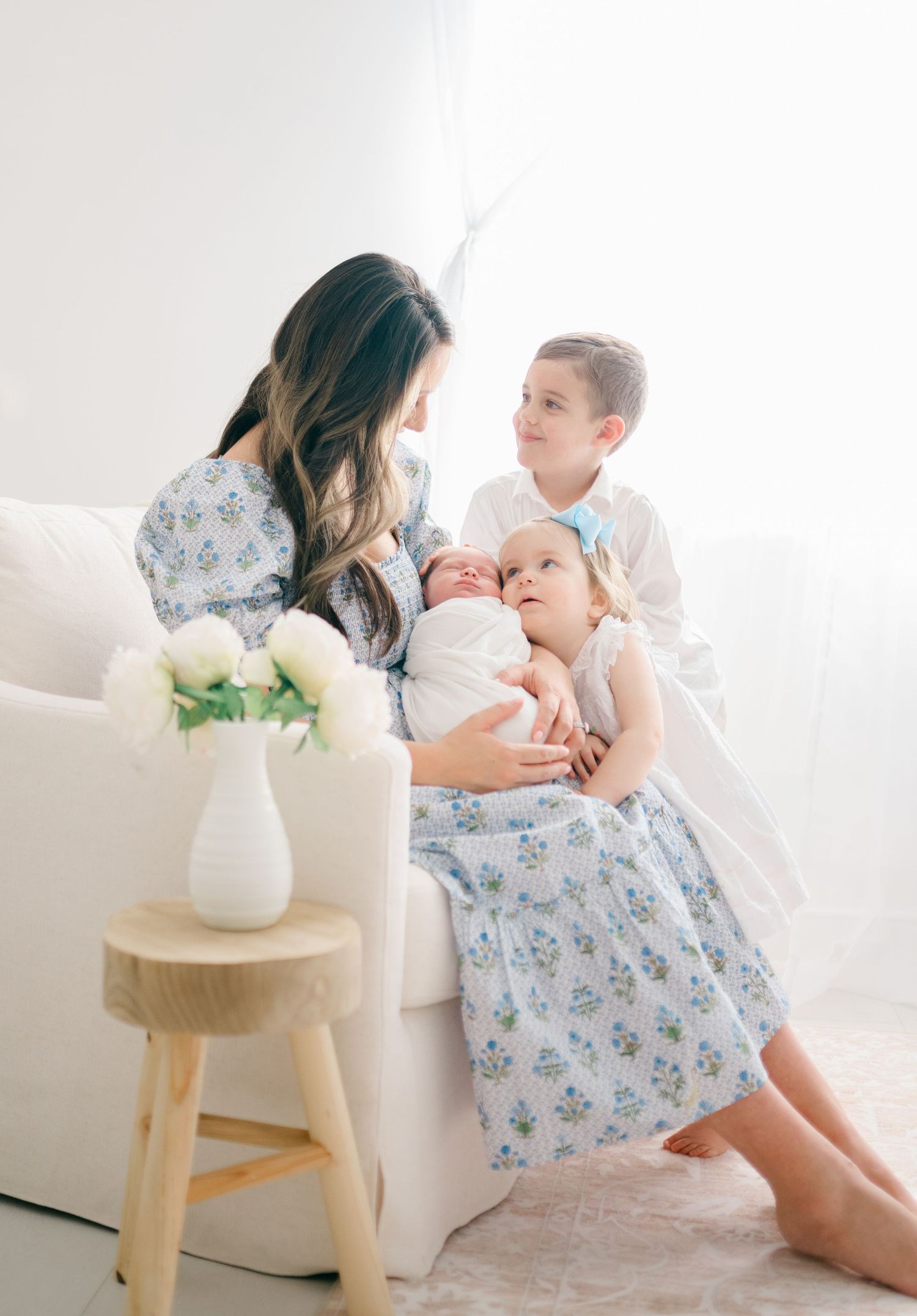 A family shares a tender moment together on a white chair in Midlothian photosession
