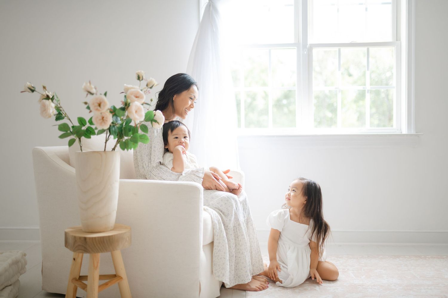 bright and airy white studio space with natural light streaming through windows and floral arrangements by Richmond newborn photographer