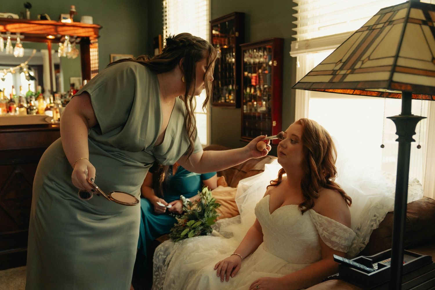 Two people share an intimate moment in a dimly lit room with decorative lamp.