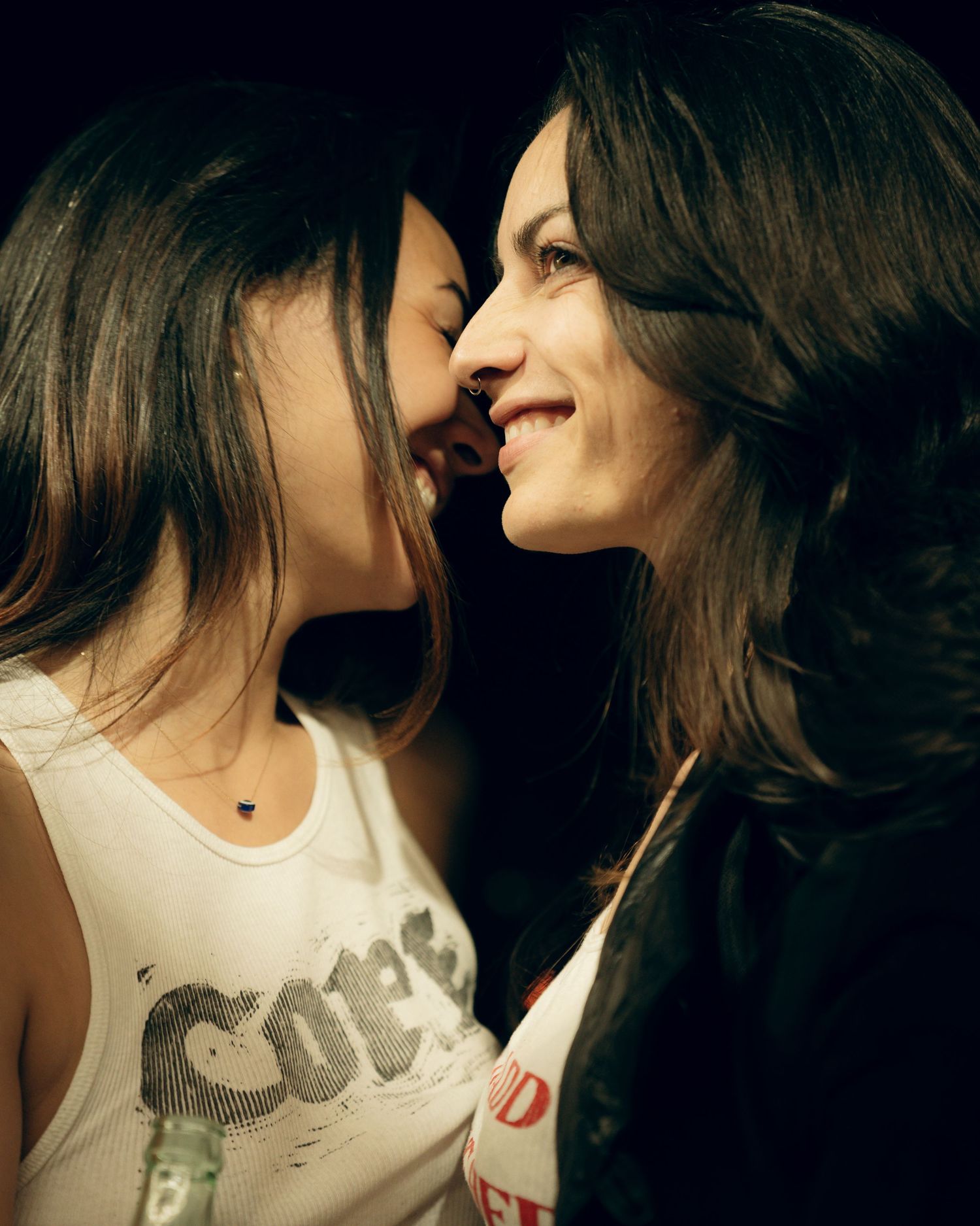 Two smiling people sharing a close intimate moment together in natural lighting.