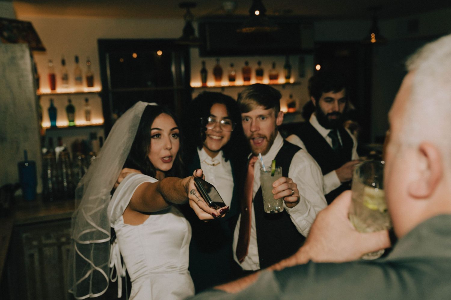 Wedding celebration at a bar with guests enjoying drinks and festivities.