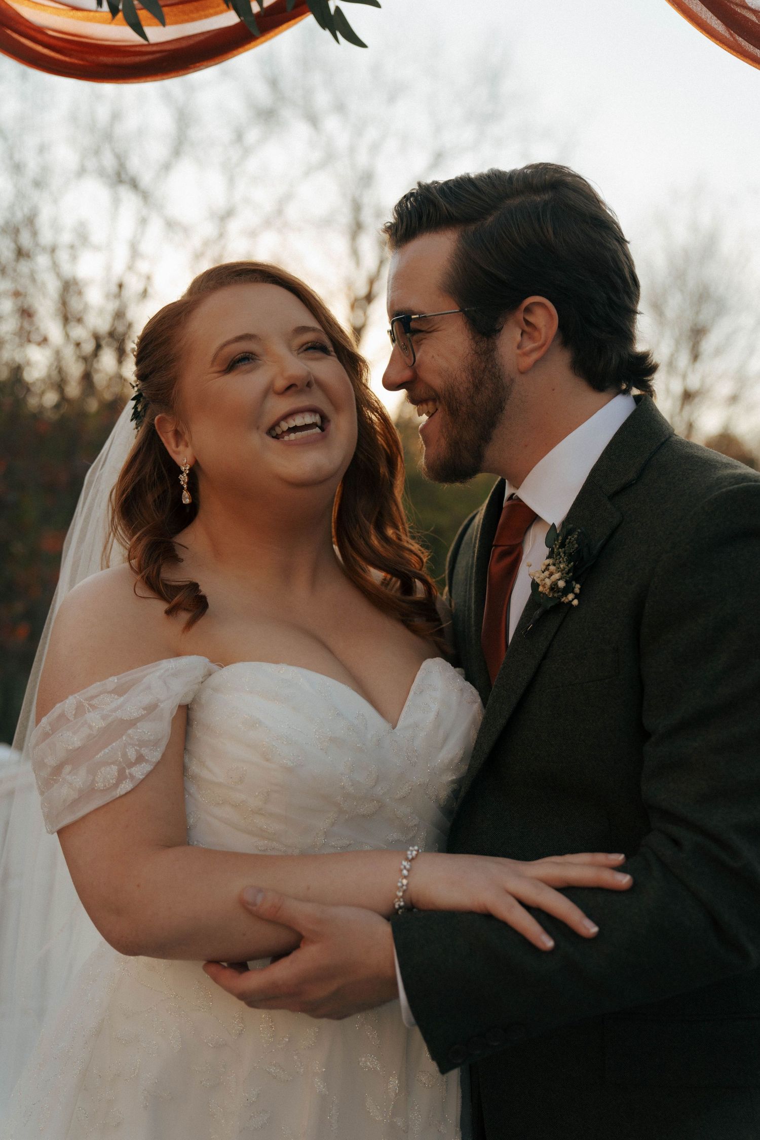 Joyful wedding moment captured during golden hour outdoors.