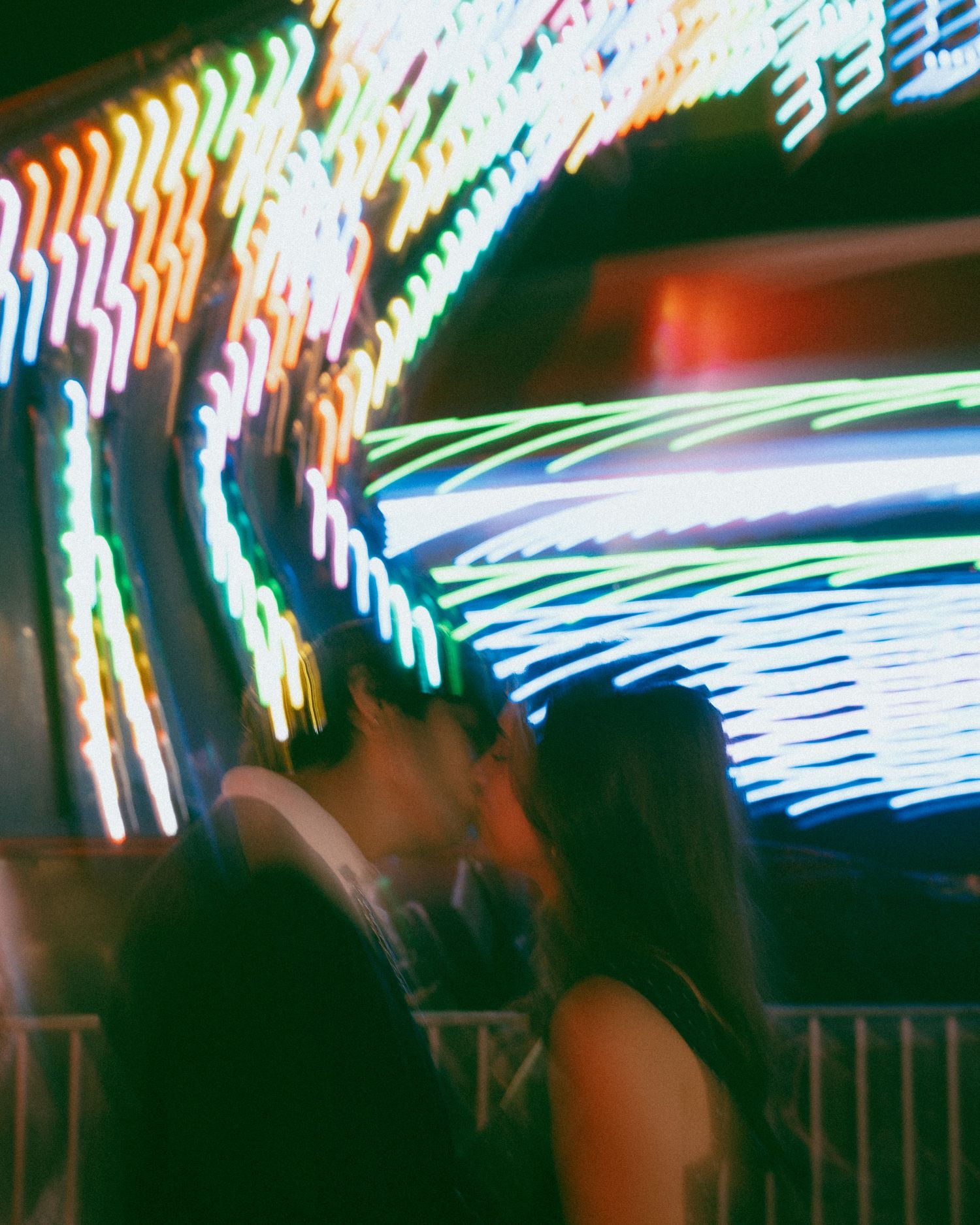 Blurred motion of colorful neon lights creating abstract streaks and patterns in the dark.
