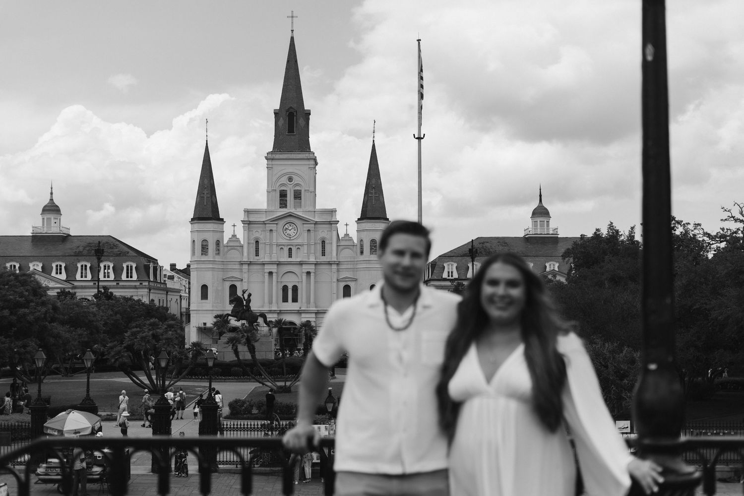 A couple poses in front of the historic St. Louis Cathedral in Jackson Square, New Orleans in black and white.