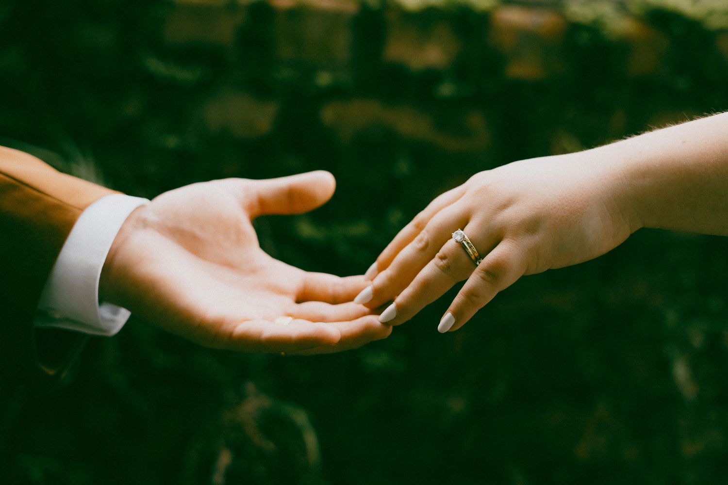 A sequence of black and white photographs showing hands reaching out and connecting with other hands.