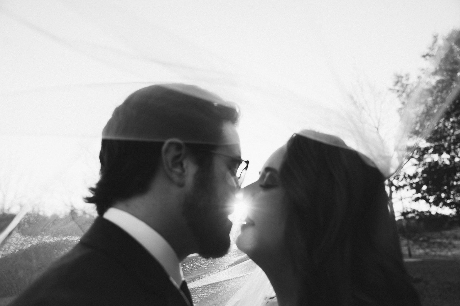 Black and white wedding portrait of a couple in an intimate close-up moment.