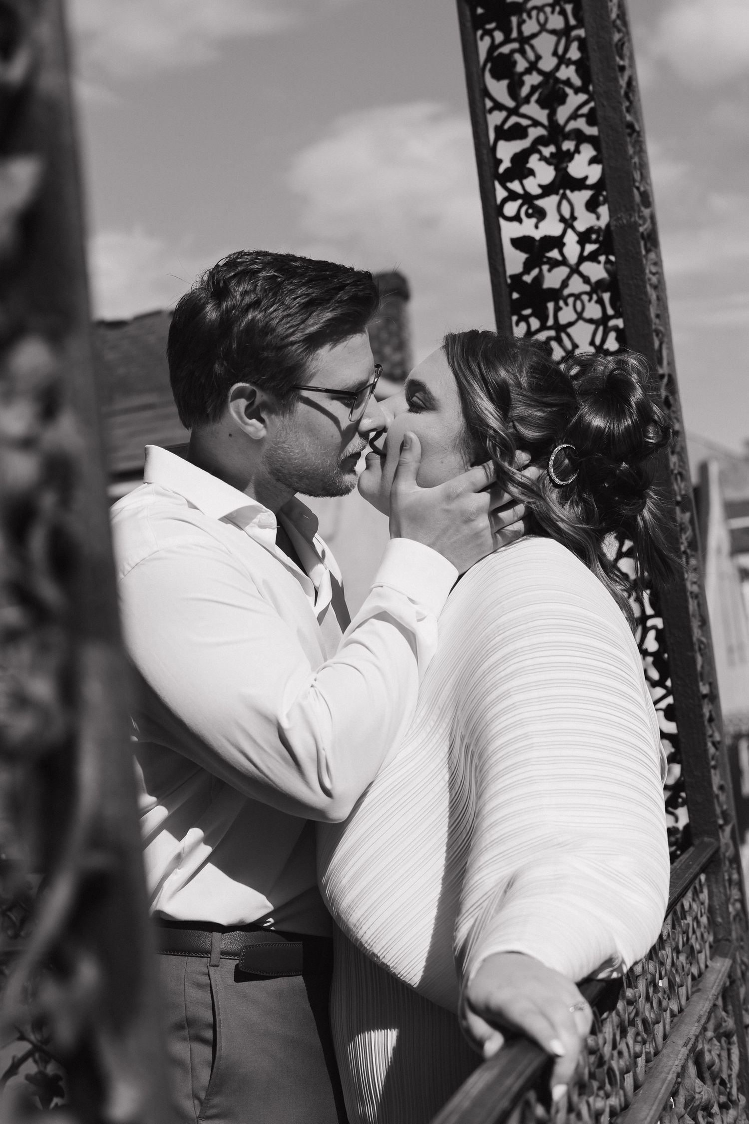 A black and white photo sequence shows a romantic couple sharing intimate moments beside an ornate pillar.