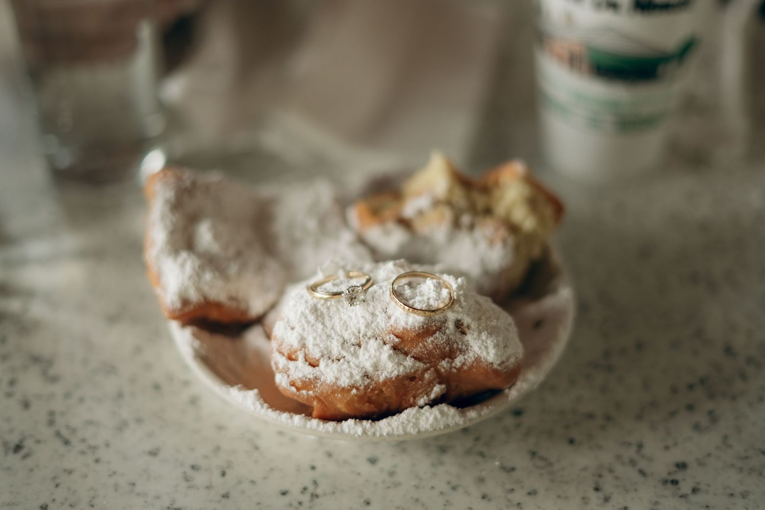 Homemade powdered sugar covered chocolate crinkle cookies rest on a rustic surface with blurred background.