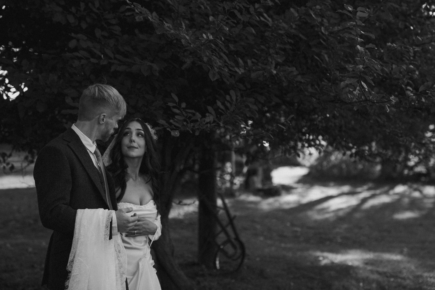 Black and white wedding portrait in a garden setting.