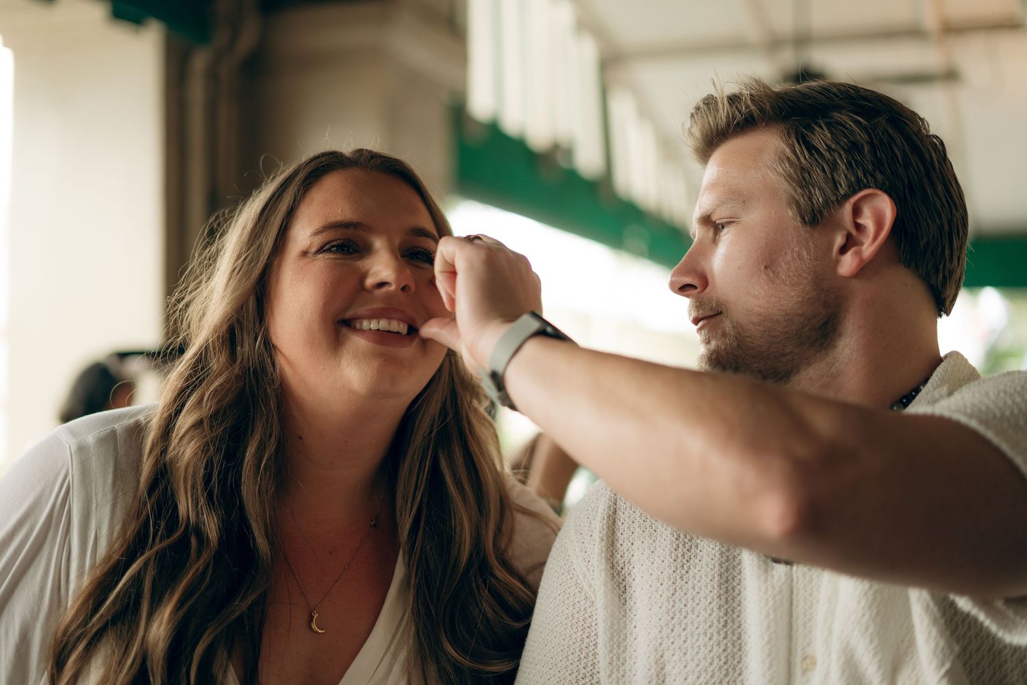A couple shares a playful moment together as they lean in close at a casual indoor setting.