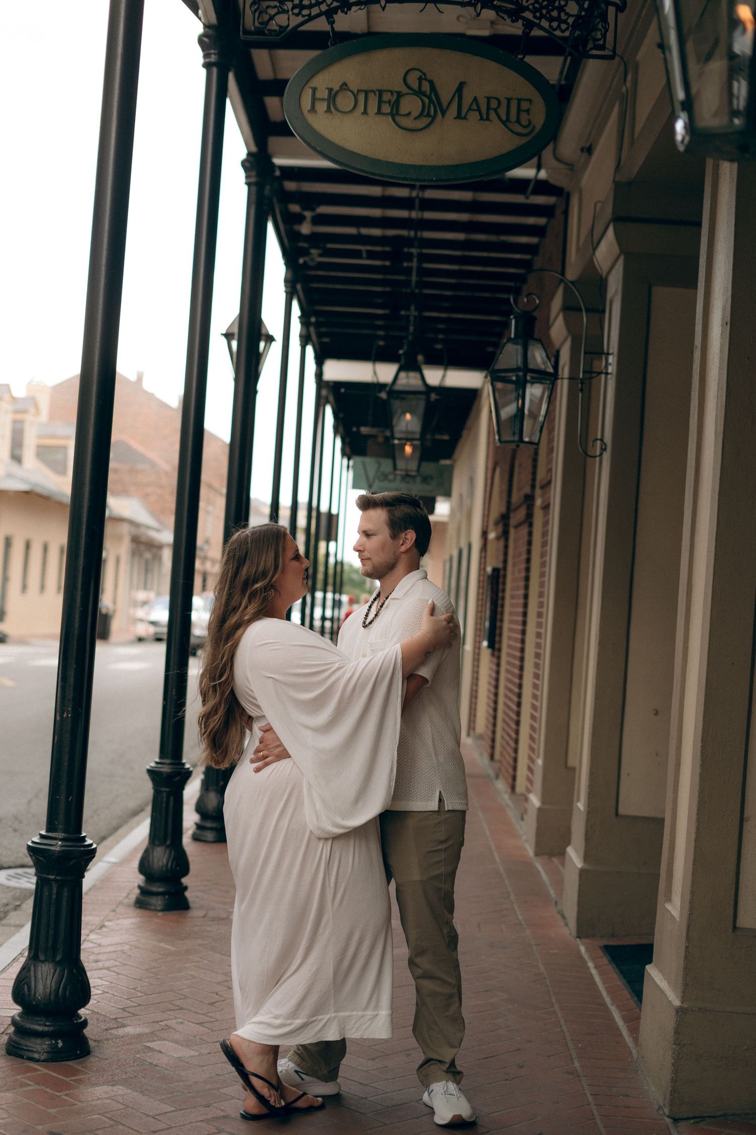 Couple sharing an intimate moment along the columned exterior of Hotel Marie.