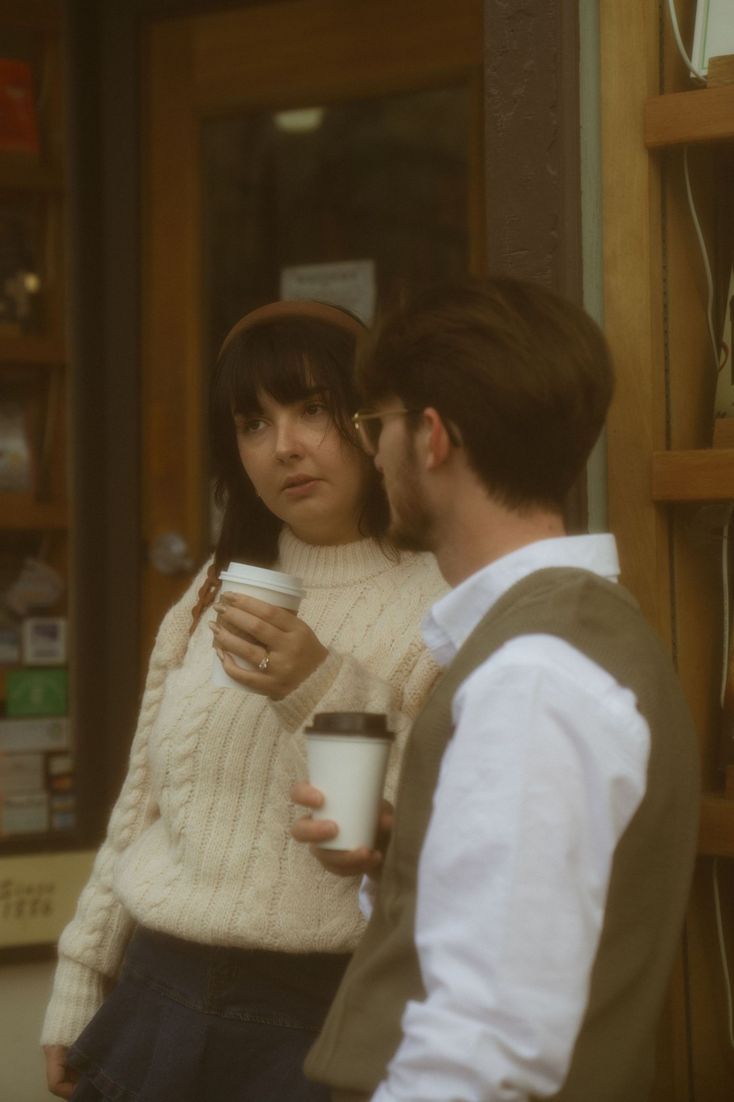 Couple standing with coffee in Bar Harbor Maine in front of Shermans Book Store