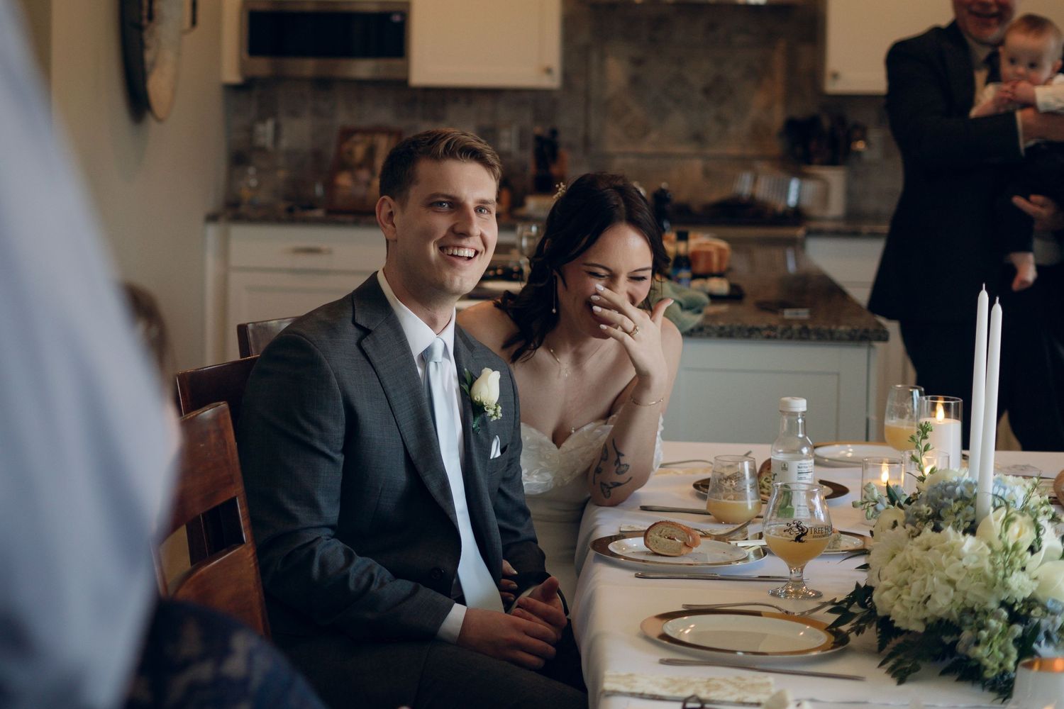 Wedding reception scene with a couple sharing a joyful moment at an elegantly set dining table.
