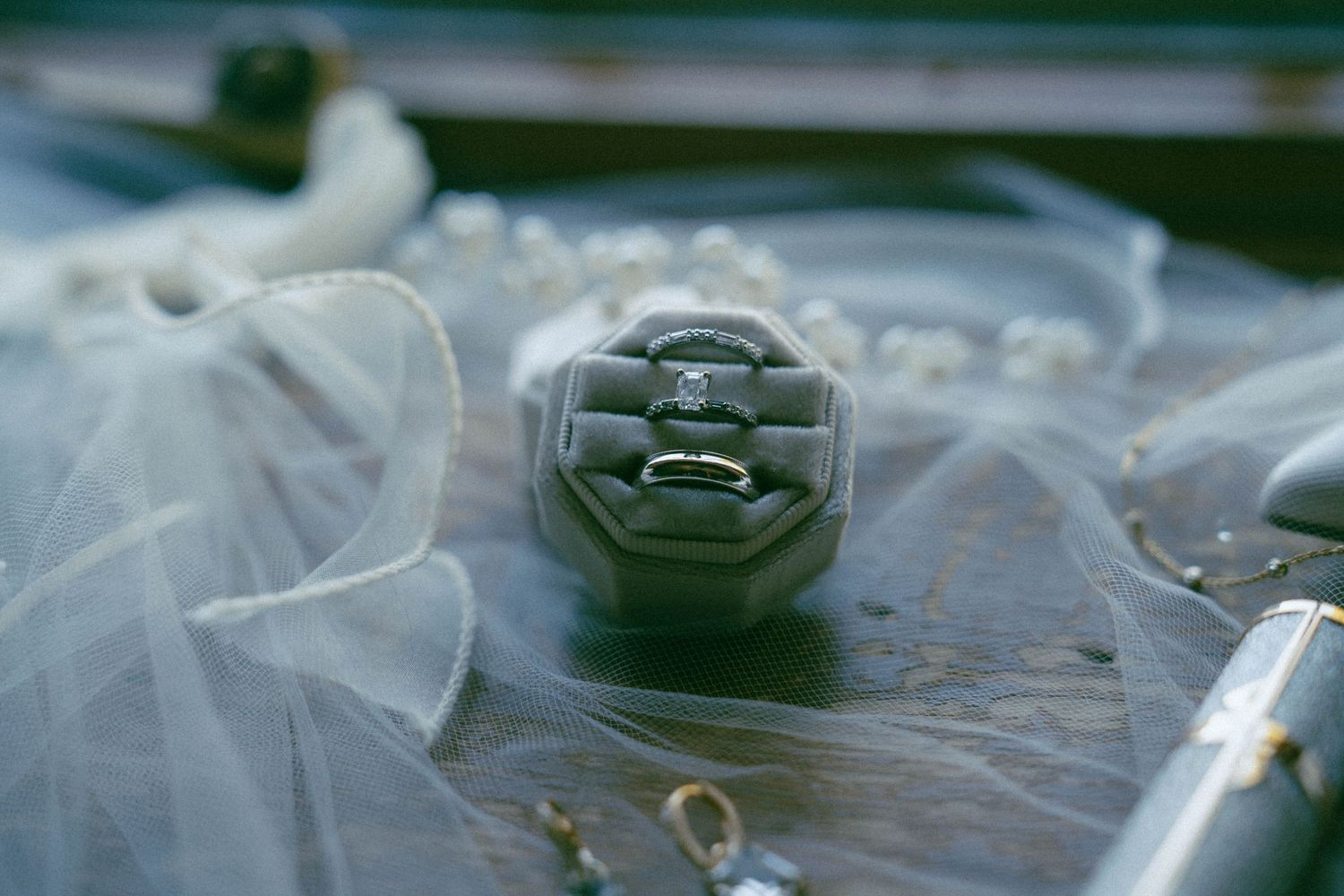 Close-up detail of wedding rings nestled in delicate white tulle fabric.