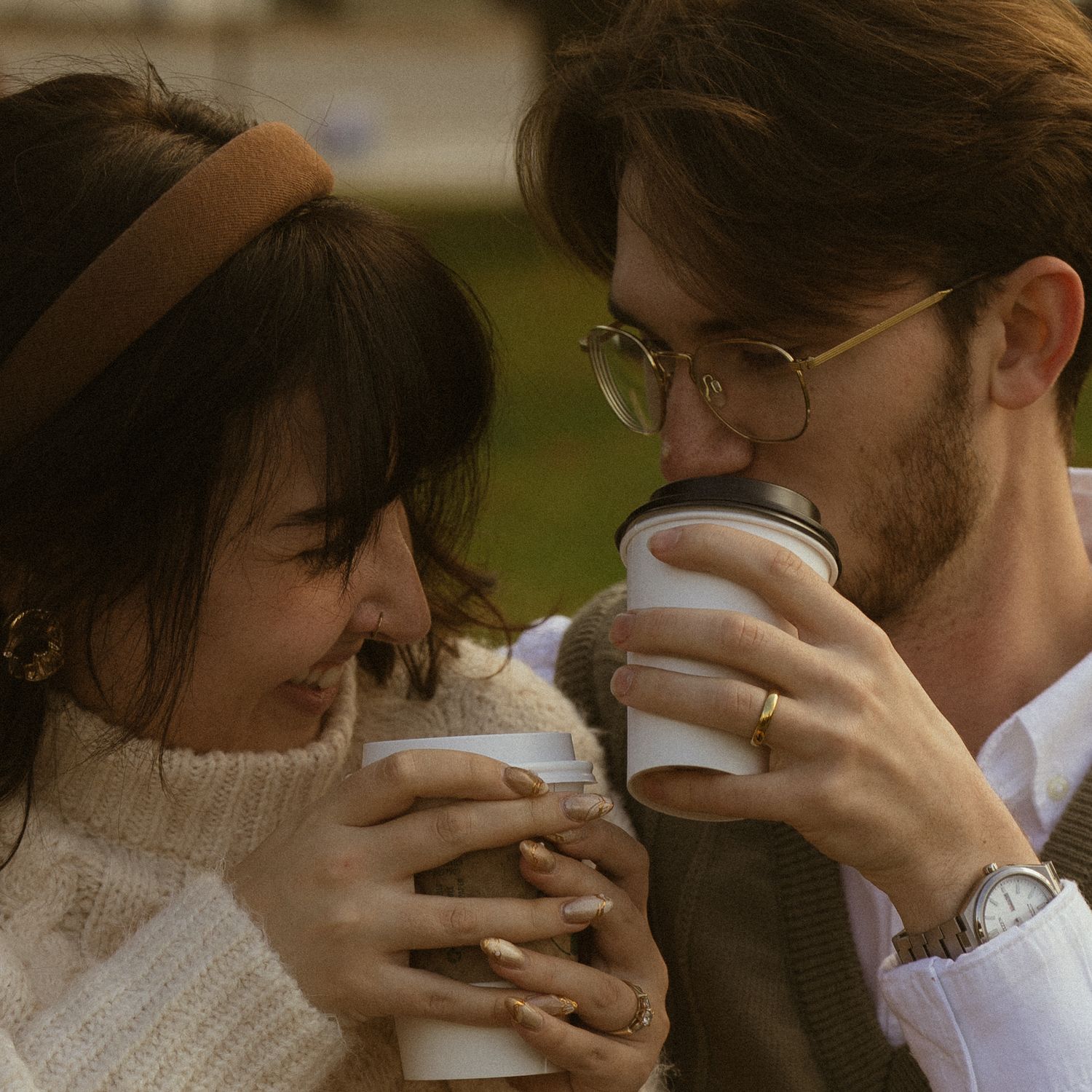 Couple sharing an intimate moment while drinking coffee together in warm sepia tones. Couple in Bar Harbor Maine