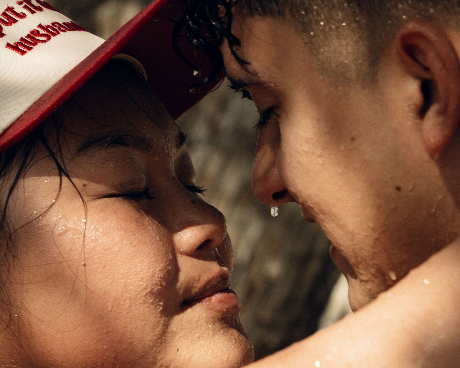 Close view of two people sharing a tender kiss in warm, romantic lighting.