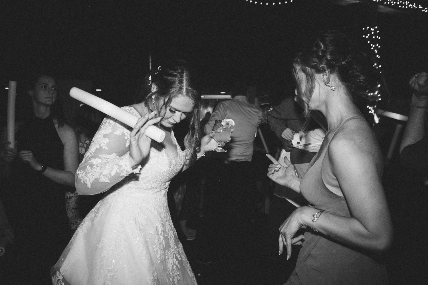 Dancing figures celebrating at a dimly lit party in black and white photography.
