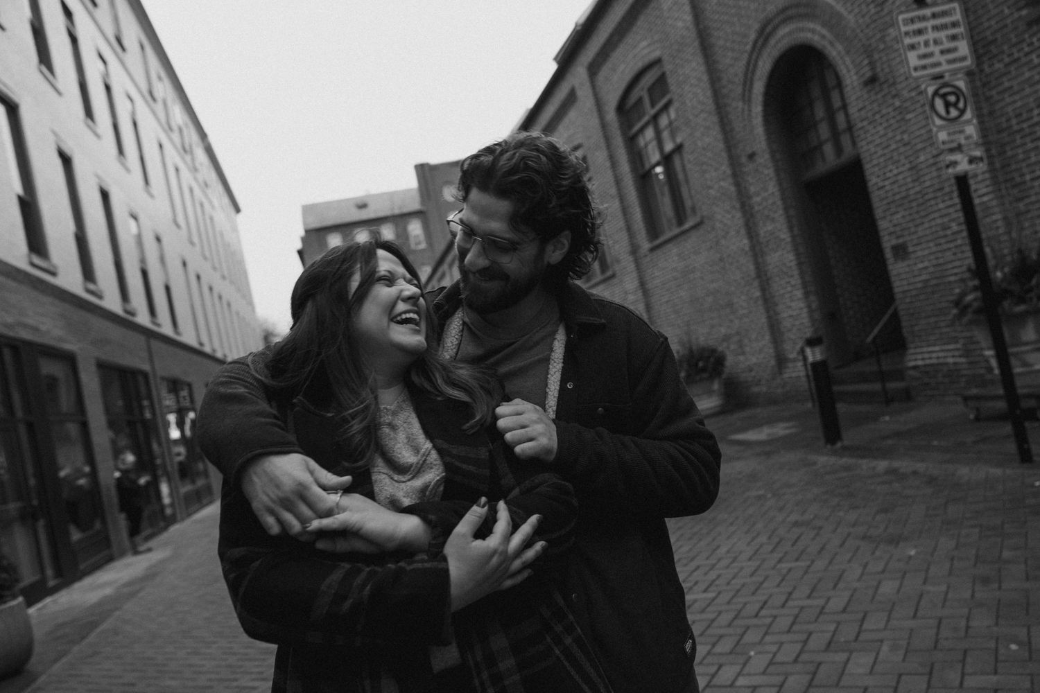 A series of four black and white photos showing spontaneous moments of joy and laughter on city streets.