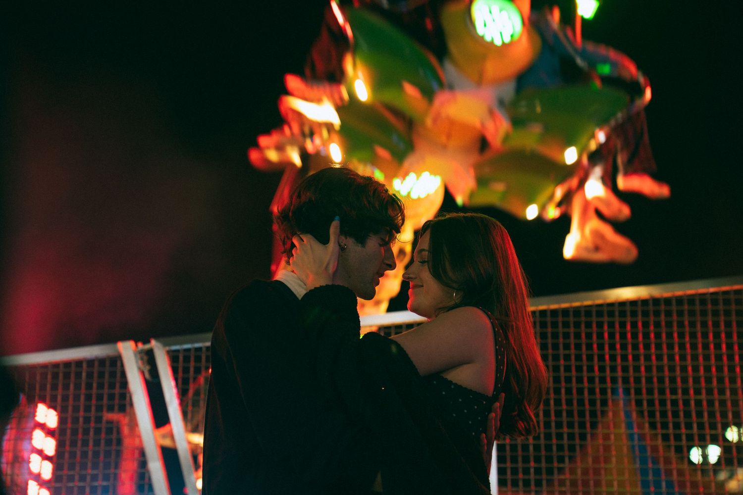 String lights create a warm ambiance as silhouetted figures dance in a dimly lit party setting.
