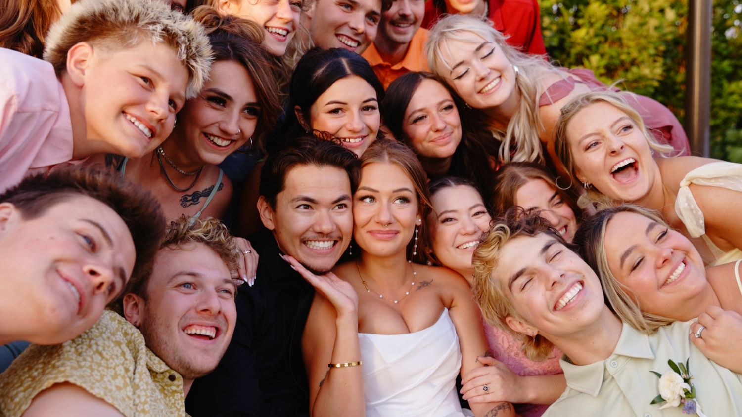 A joyful group poses together for a series of casual selfie photos in an outdoor setting.