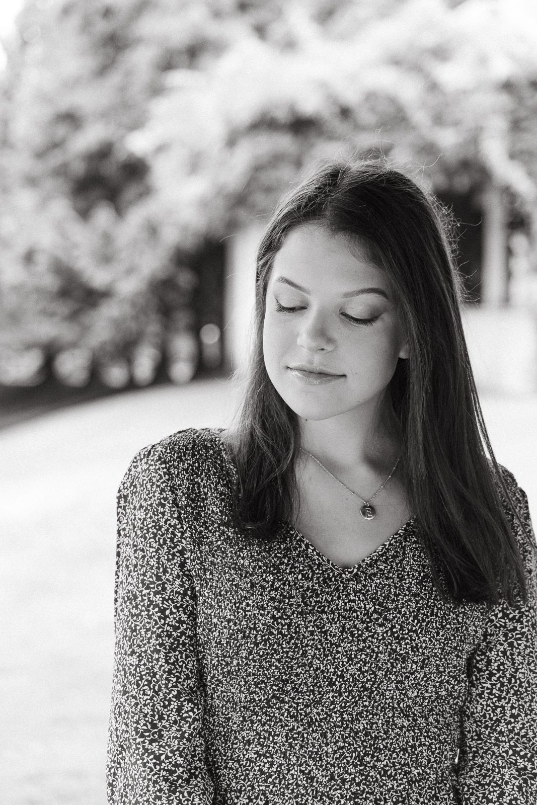 Black and white portrait of person with long hair wearing patterned sweater.