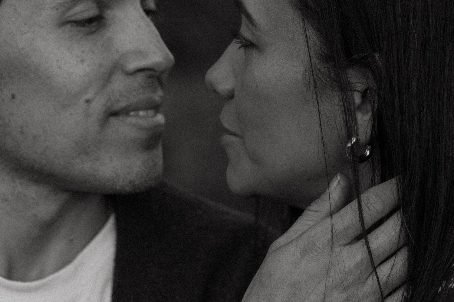 Intimate black and white portrait of couple in close embrace.