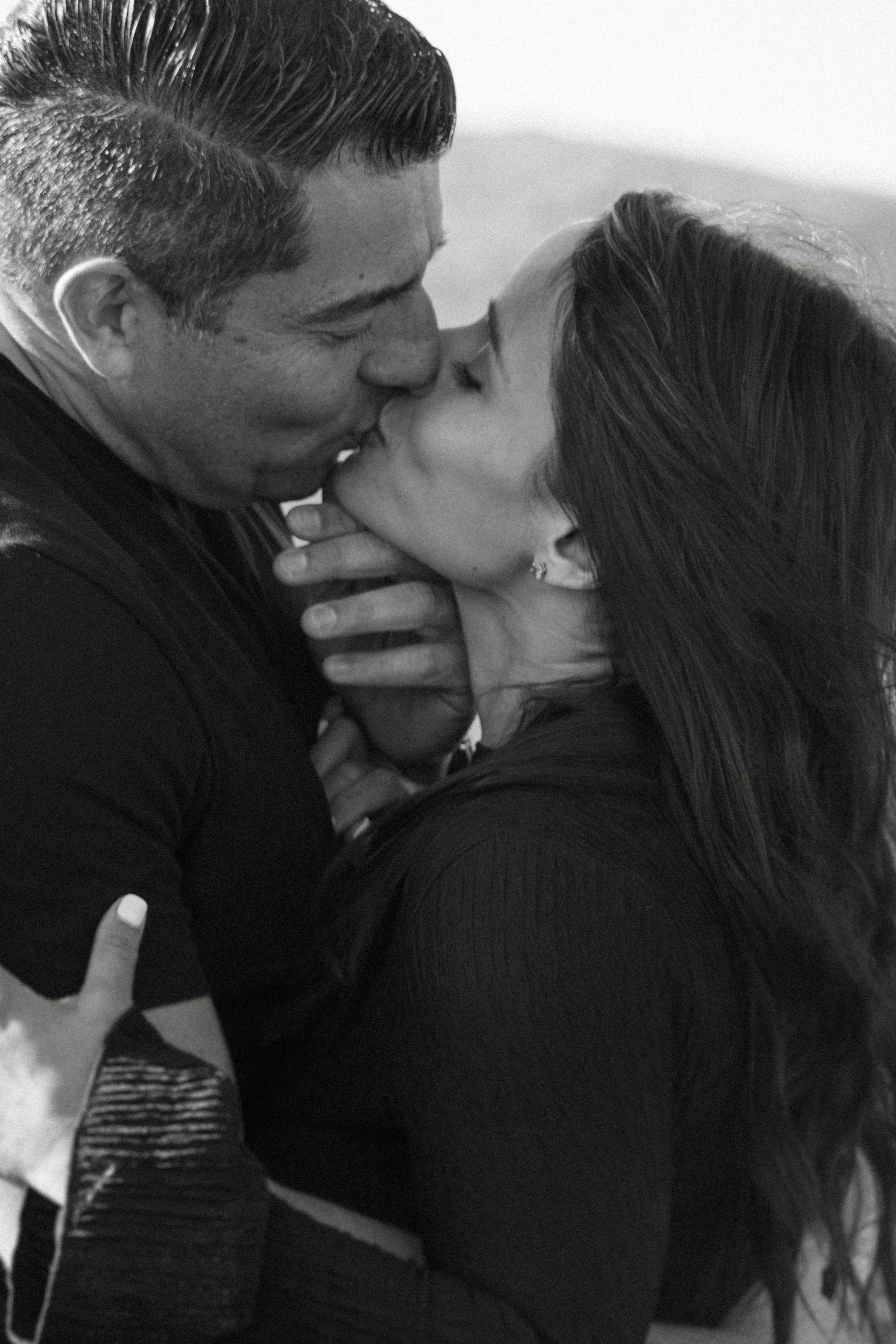 Black and white close-up of intimate kiss between romantic couple.