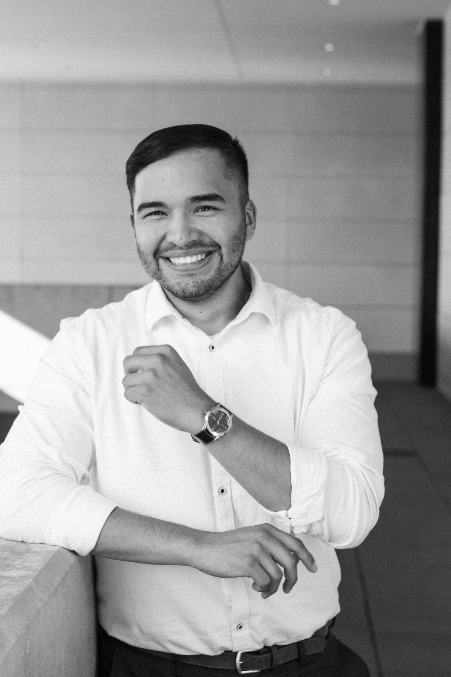 Professional portrait of person in white button-up shirt smiling warmly.