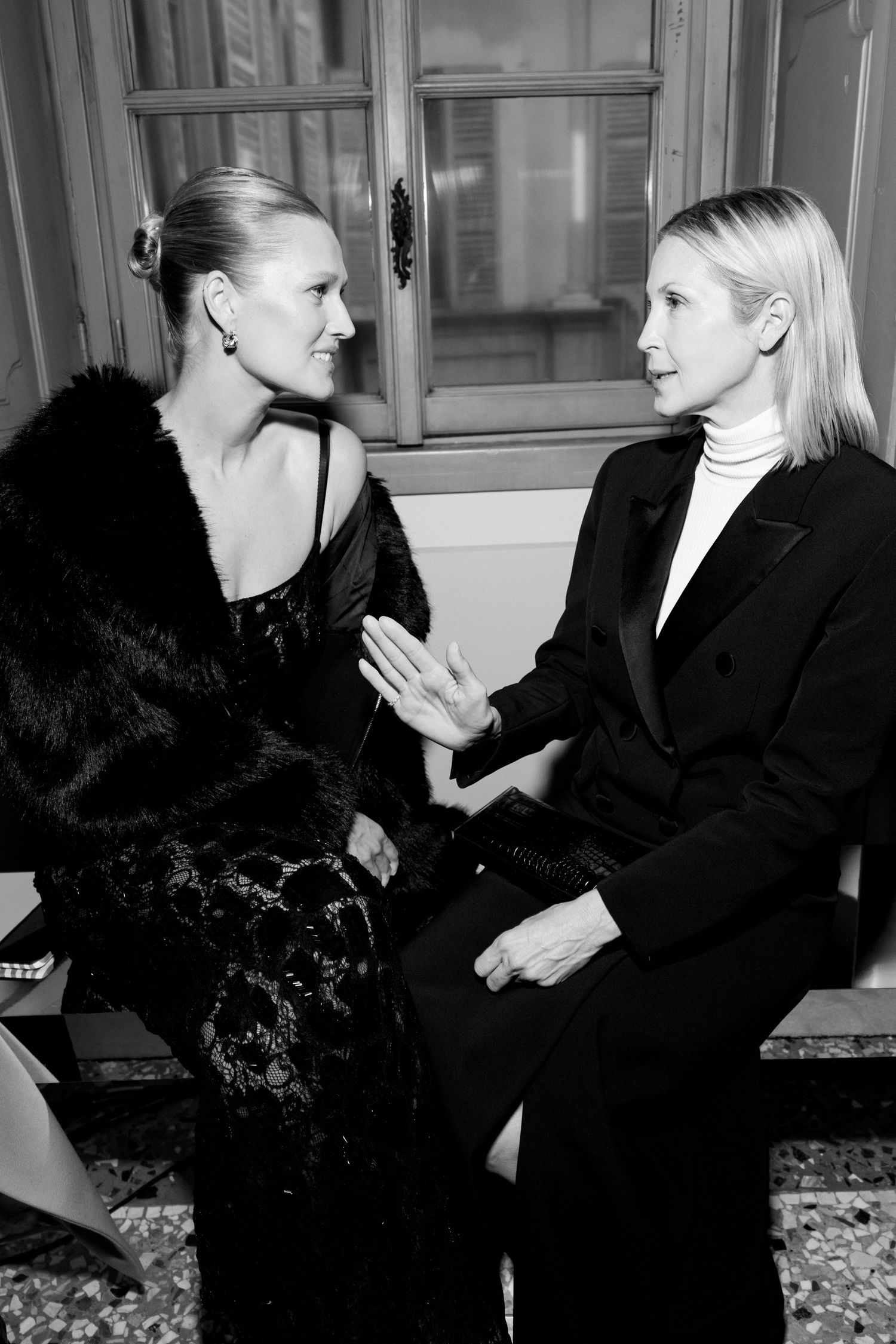 Black and white photo series showing two people in elegant attire having an animated conversation.