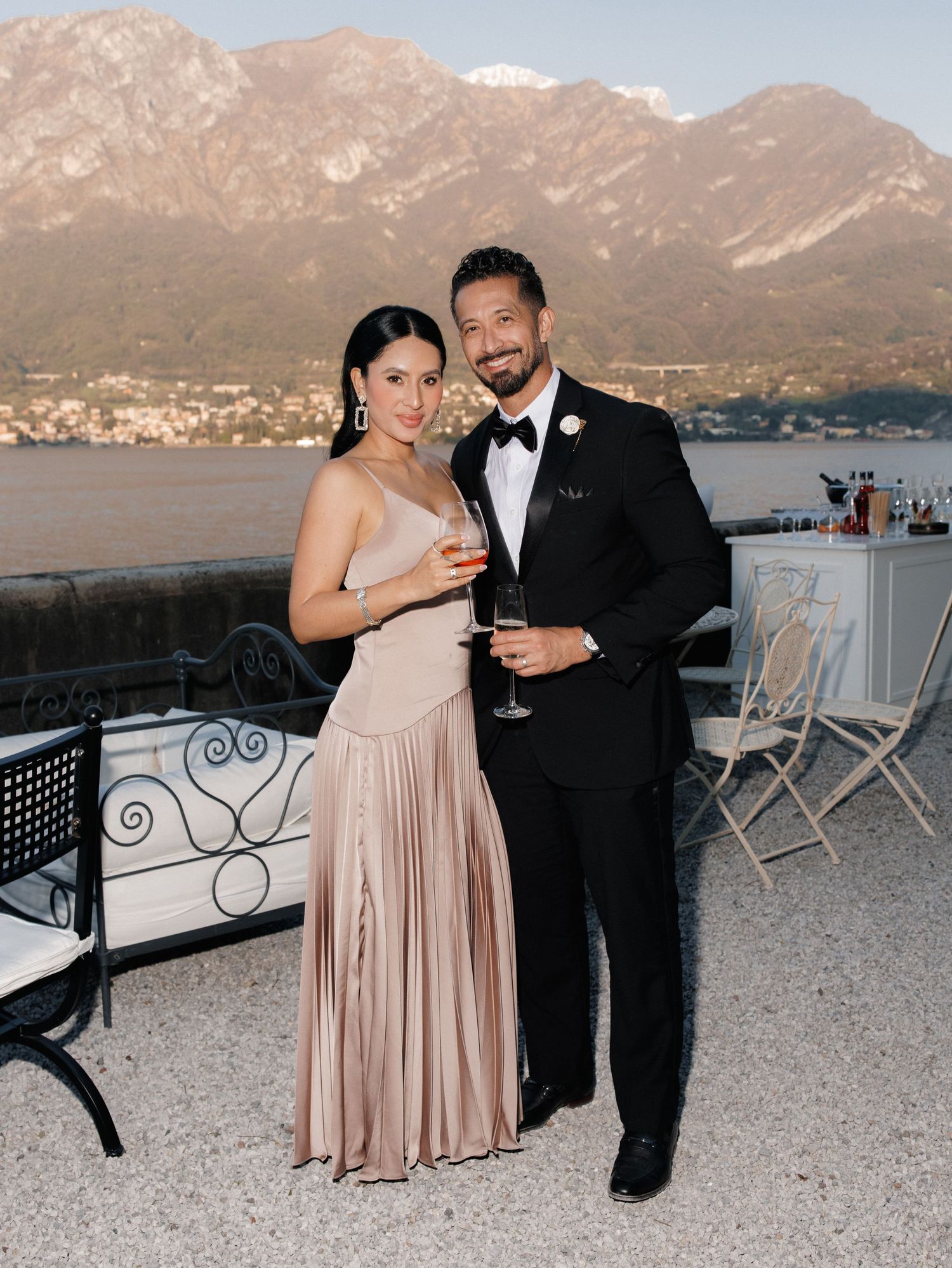 A couple shares an intimate moment on a balcony overlooking scenic mountain views during their wedding celebration.
