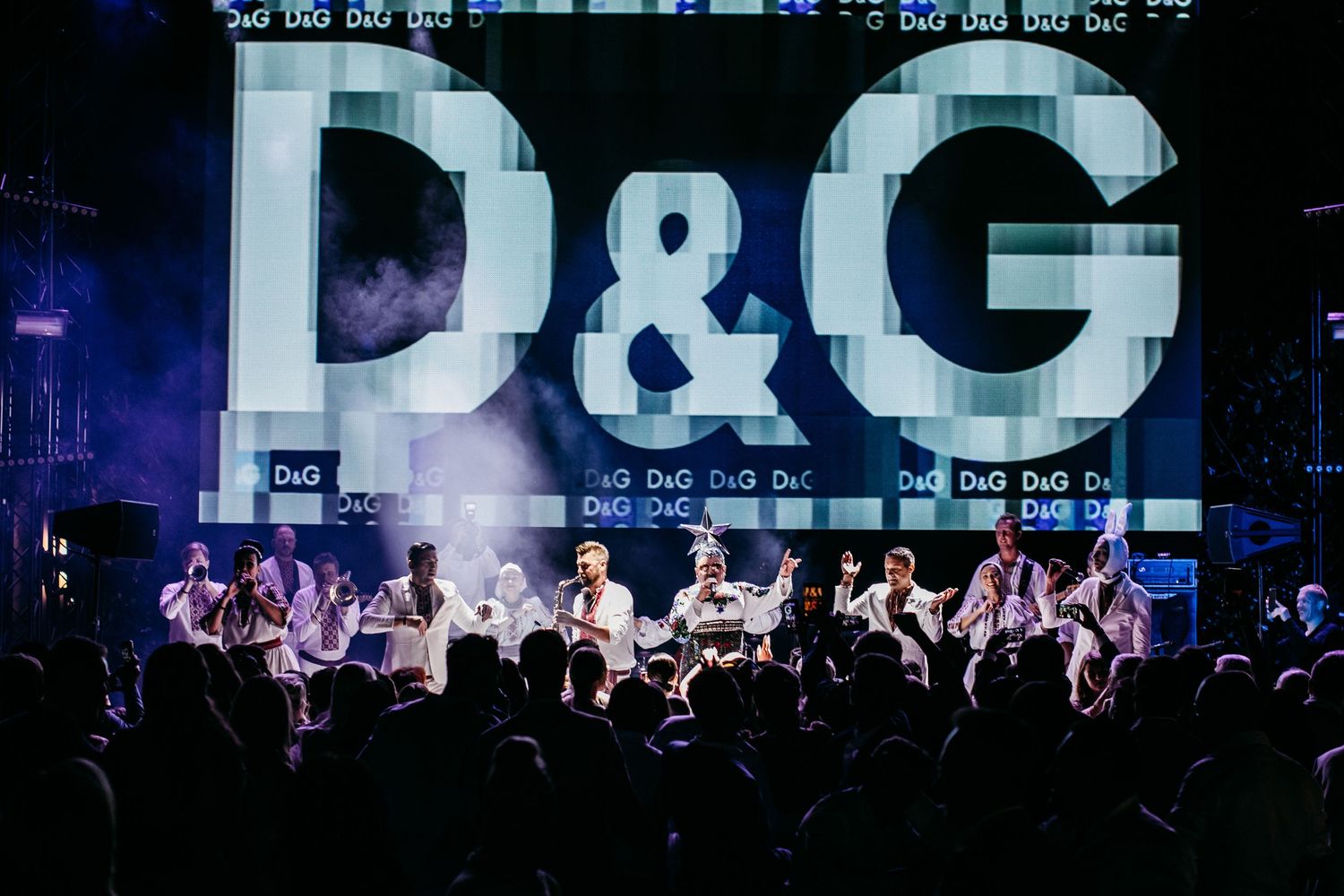 A concert crowd watches D&G perform on stage with large illuminated letters.