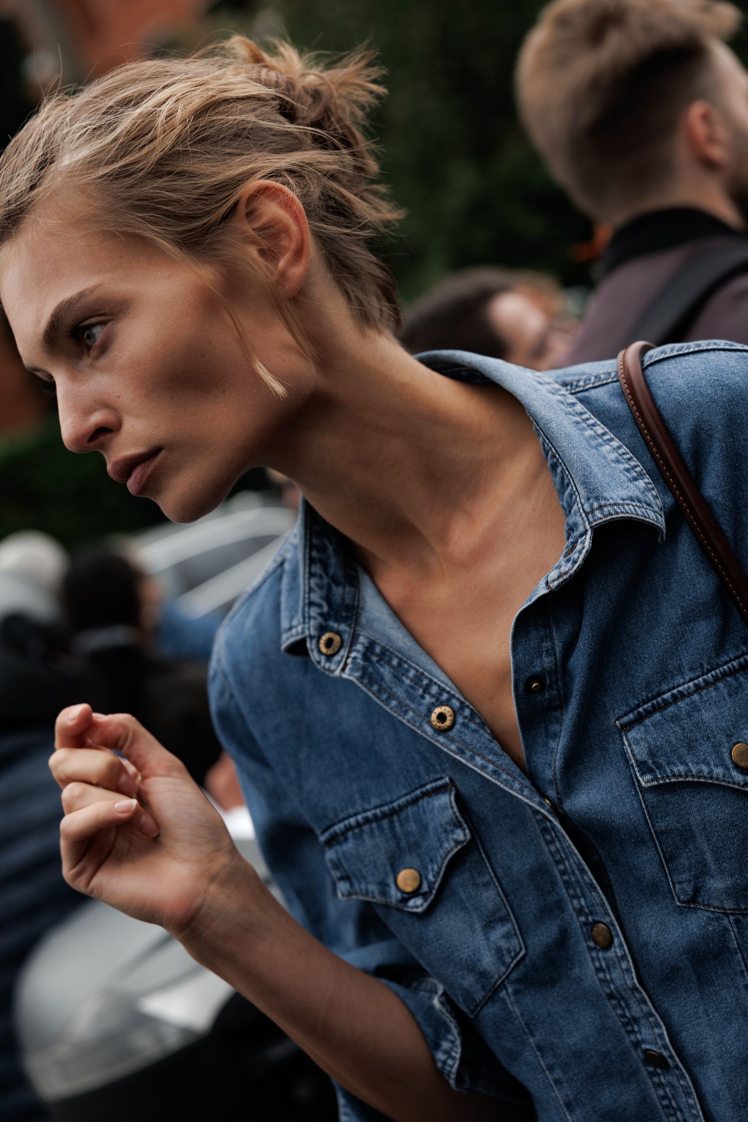 A person wearing a denim jacket is shown in a series of close-up shots with moody lighting and dramatic poses.
