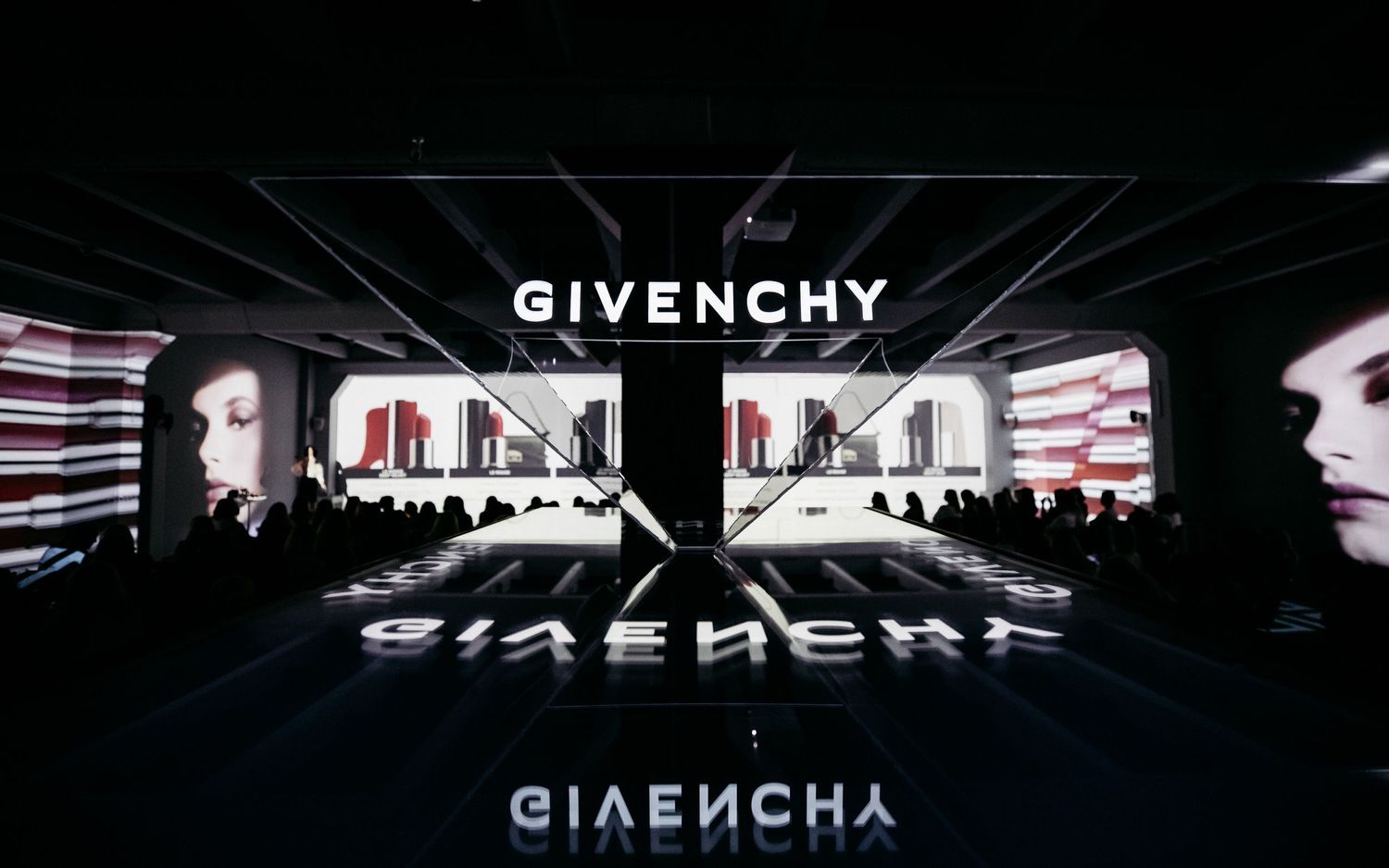 Dramatic Givenchy fashion show stage setup with mirrored surfaces and stark lighting effects.