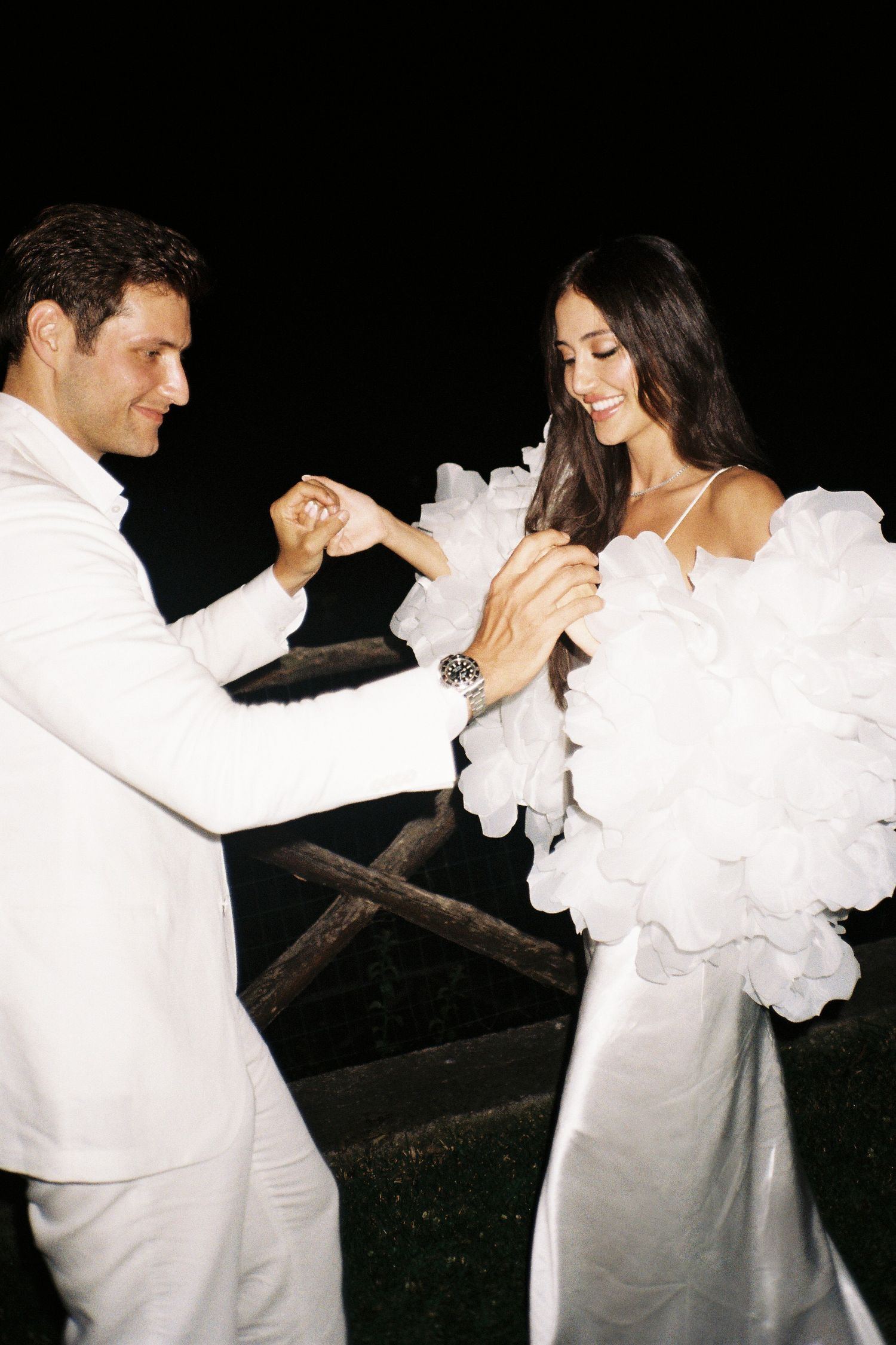 A couple in white outfits dancing together in a romantic sequence of black and white photographs.