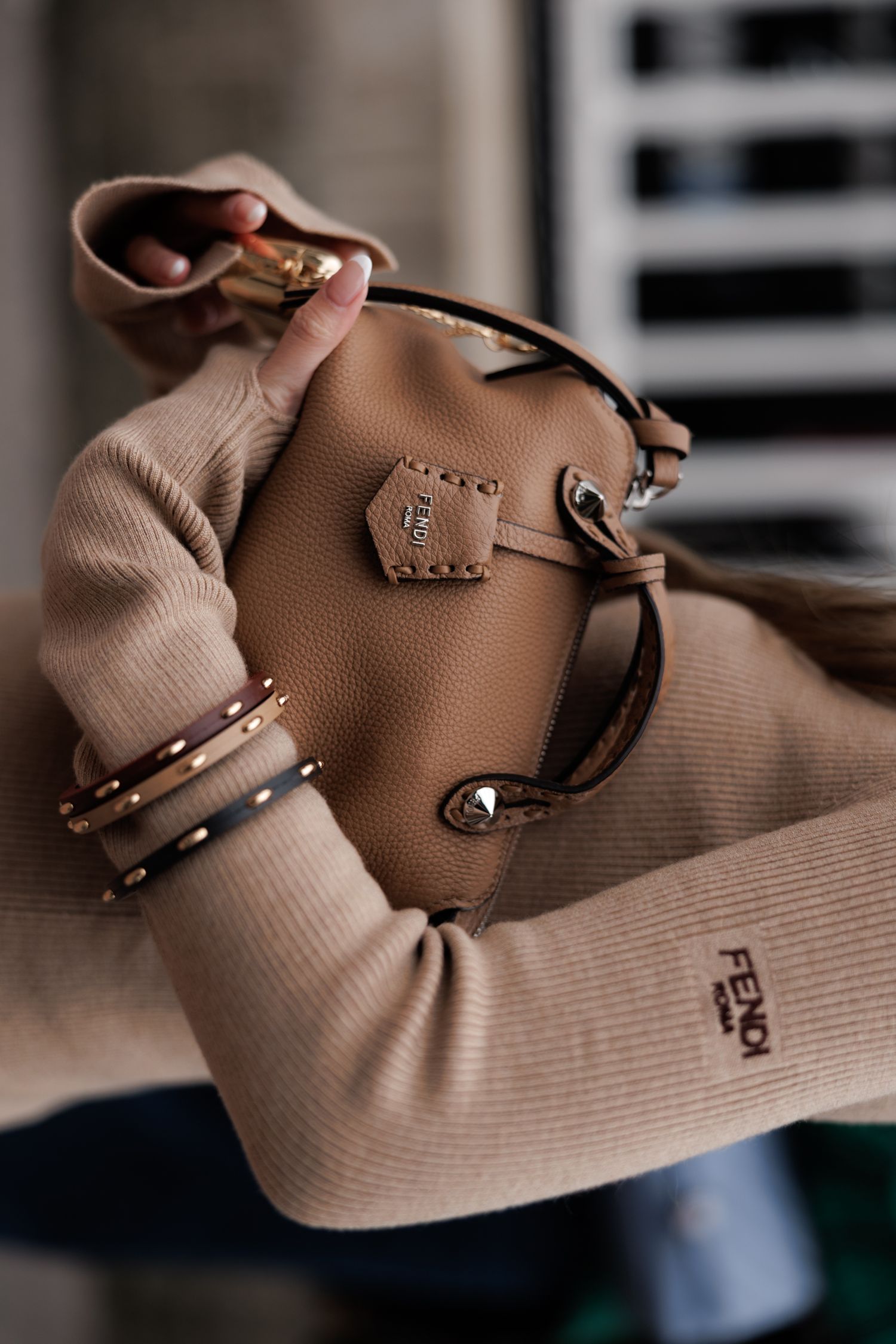 Close-up shots of a brown leather handbag with gold hardware details against a beige knit fabric background.