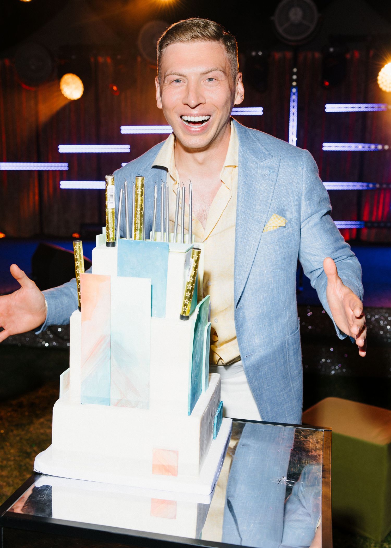A celebratory scene with a modern blue and white tiered cake at an upscale venue.