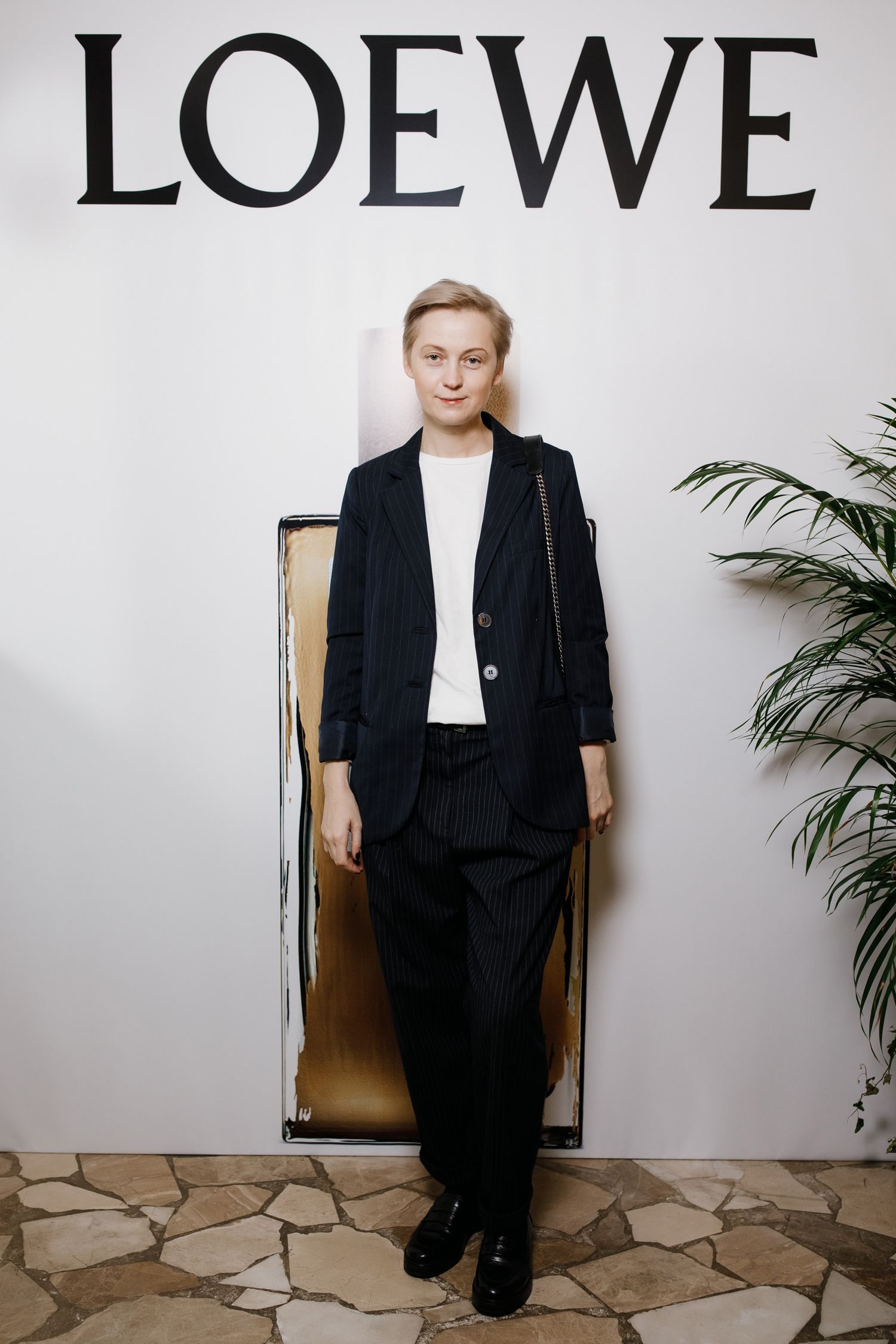 Fashion presentation with Loewe logo backdrop and minimalist styling.